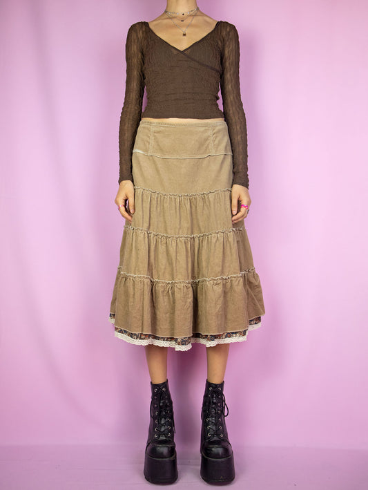 The Y2K Brown Corduroy Tiered Skirt is a vintage 2000s cottage prairie inspired&nbsp; light brown beige peasant midi skirt with a side zipper closure.