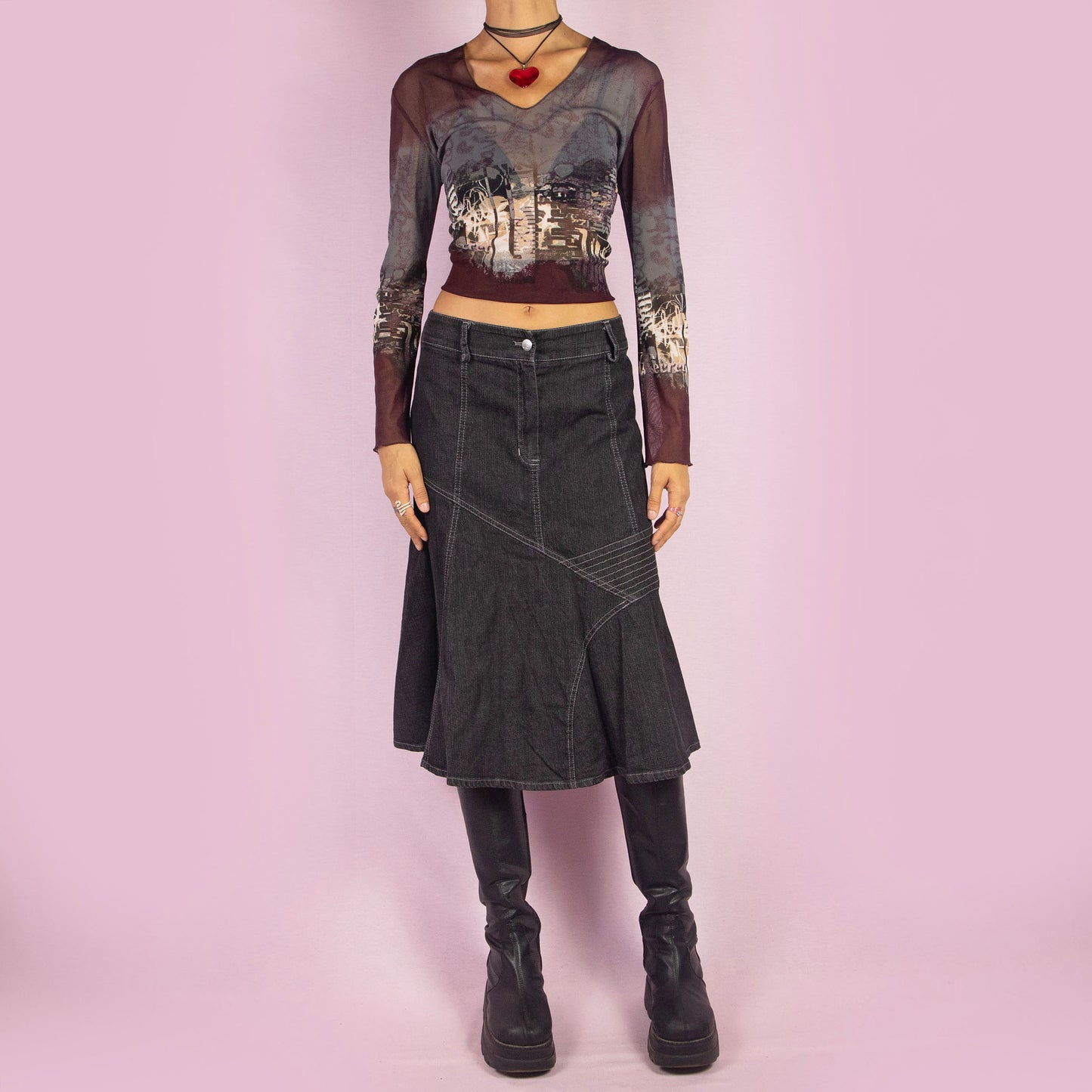 The Y2K Trumpet Dark Denim Skirt is a vintage 2000s piece featuring a high-waist design with a front zipper and button closure. The skirt is crafted from a stretchy black-grayish denim with panelled construction and white contrast stitching, creating a flattering trumpet silhouette. Perfect for casual, everyday looks.