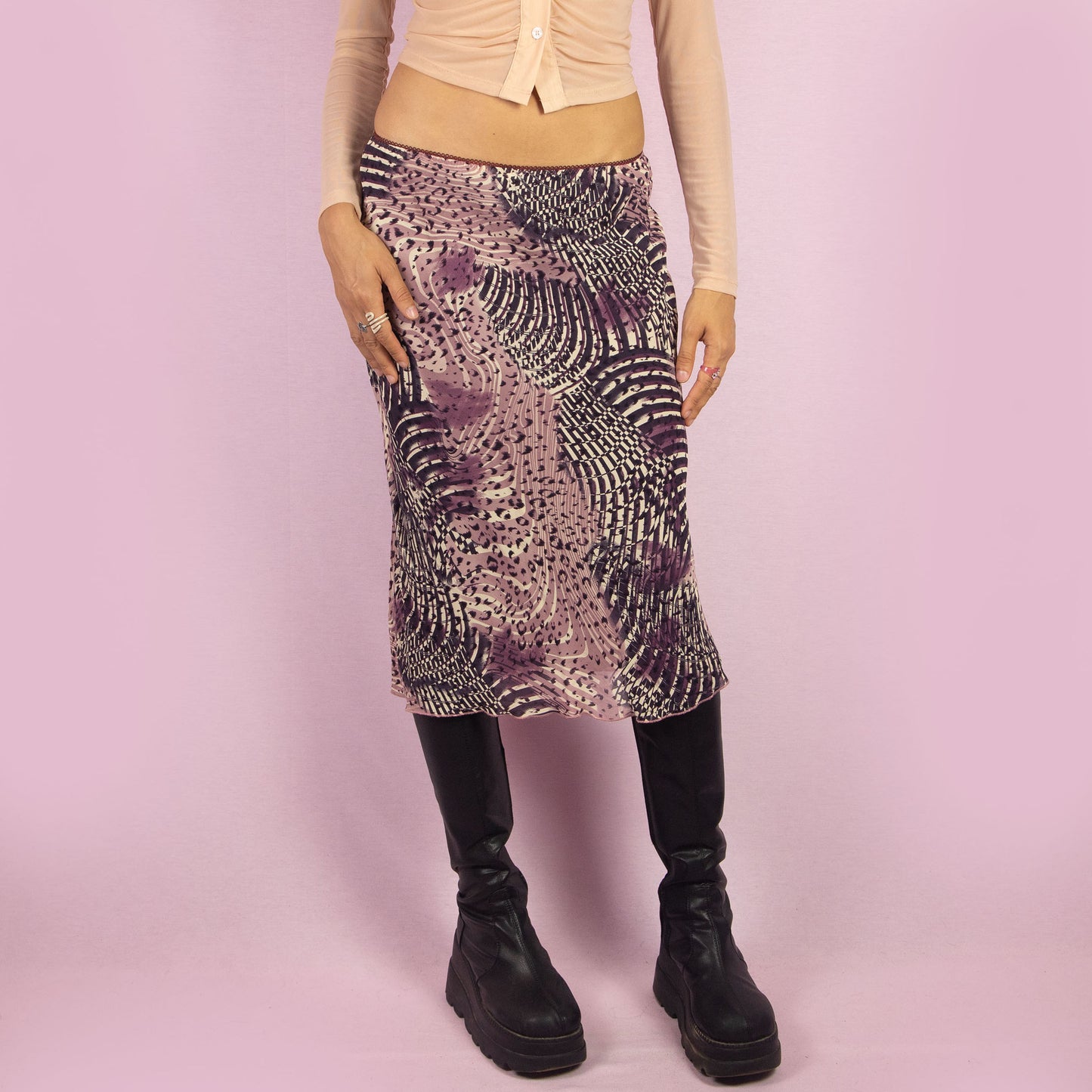 The Y2K Abstract Print Midi Skirt is a vintage 2000s piece featuring a vibrant abstract print in shades of purple and an elastic waistband. Perfect for casual outings or a summer night look.