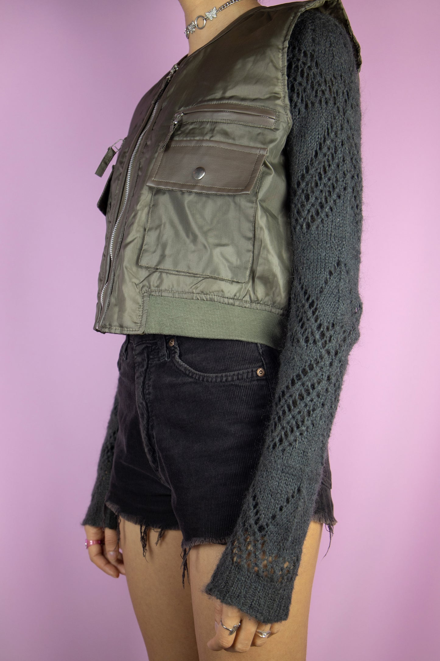 The Vintage 90s Utility Cargo Vest Jacket is a khaki green vest with pockets and a zipper closure. Cyber goth grunge 1990s techwear tactical jacket.
