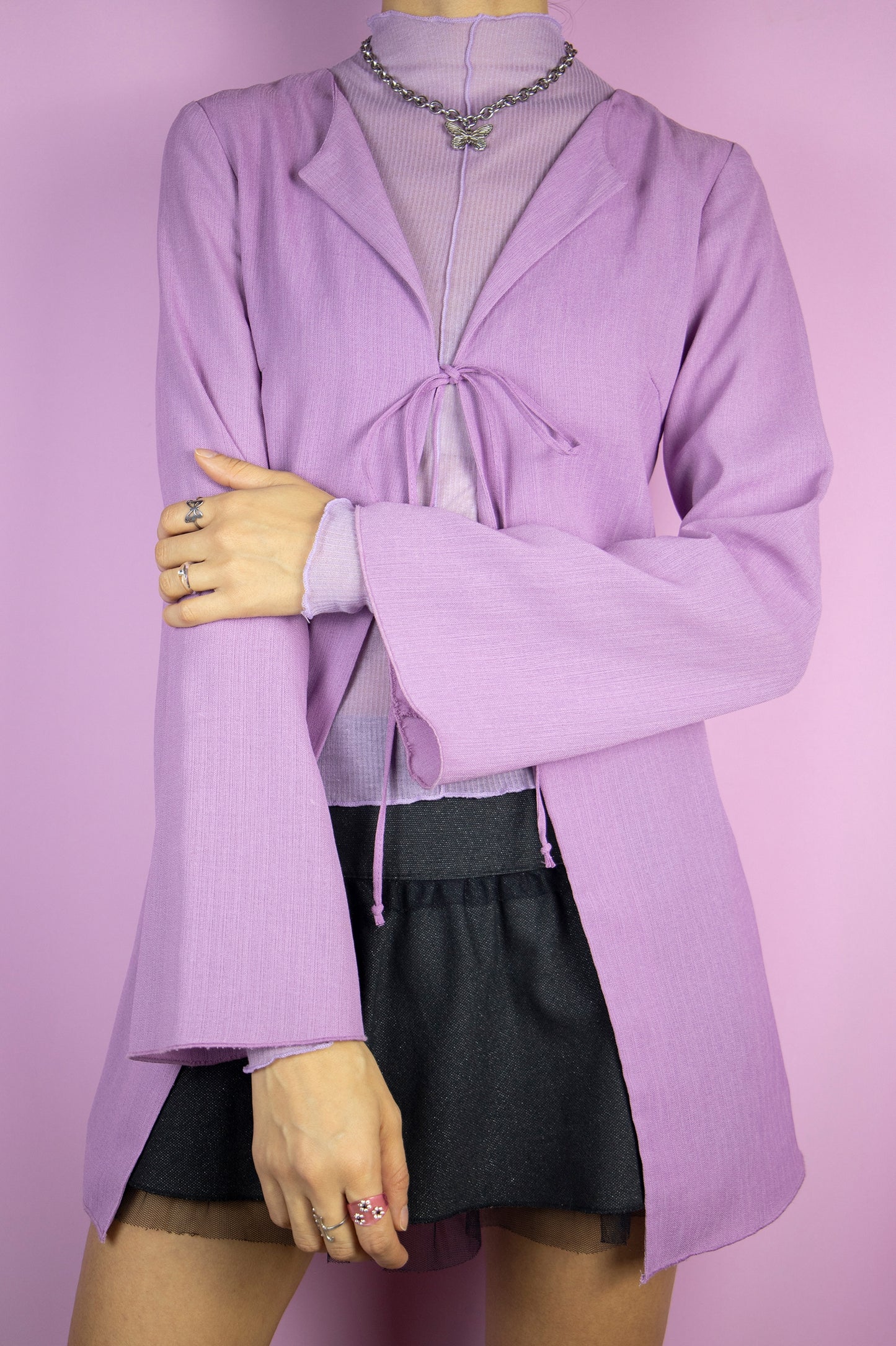 The Y2K Purple Duster Jacket is a vintage lilac top that ties at the front and has bell sleeves. Boho romantic 2000s bolero jacket.