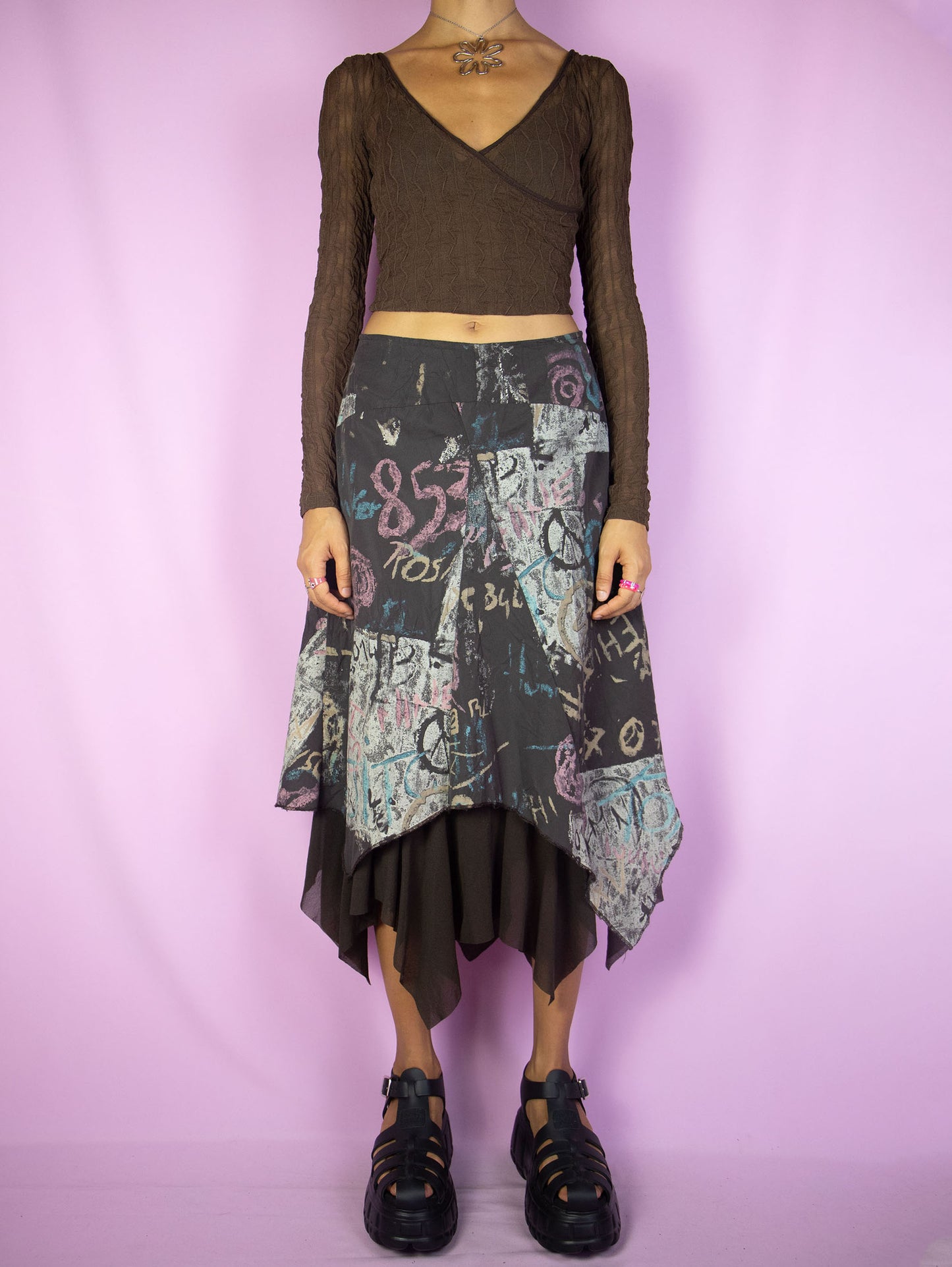 The Y2K Layered Asymmetric Midi Skirt is a vintage 2000s cyber subversive party style dark brown abstract printed skirt with a pointed asymmetrical semi-sheer mesh hem and side zipper closure. Made in France.