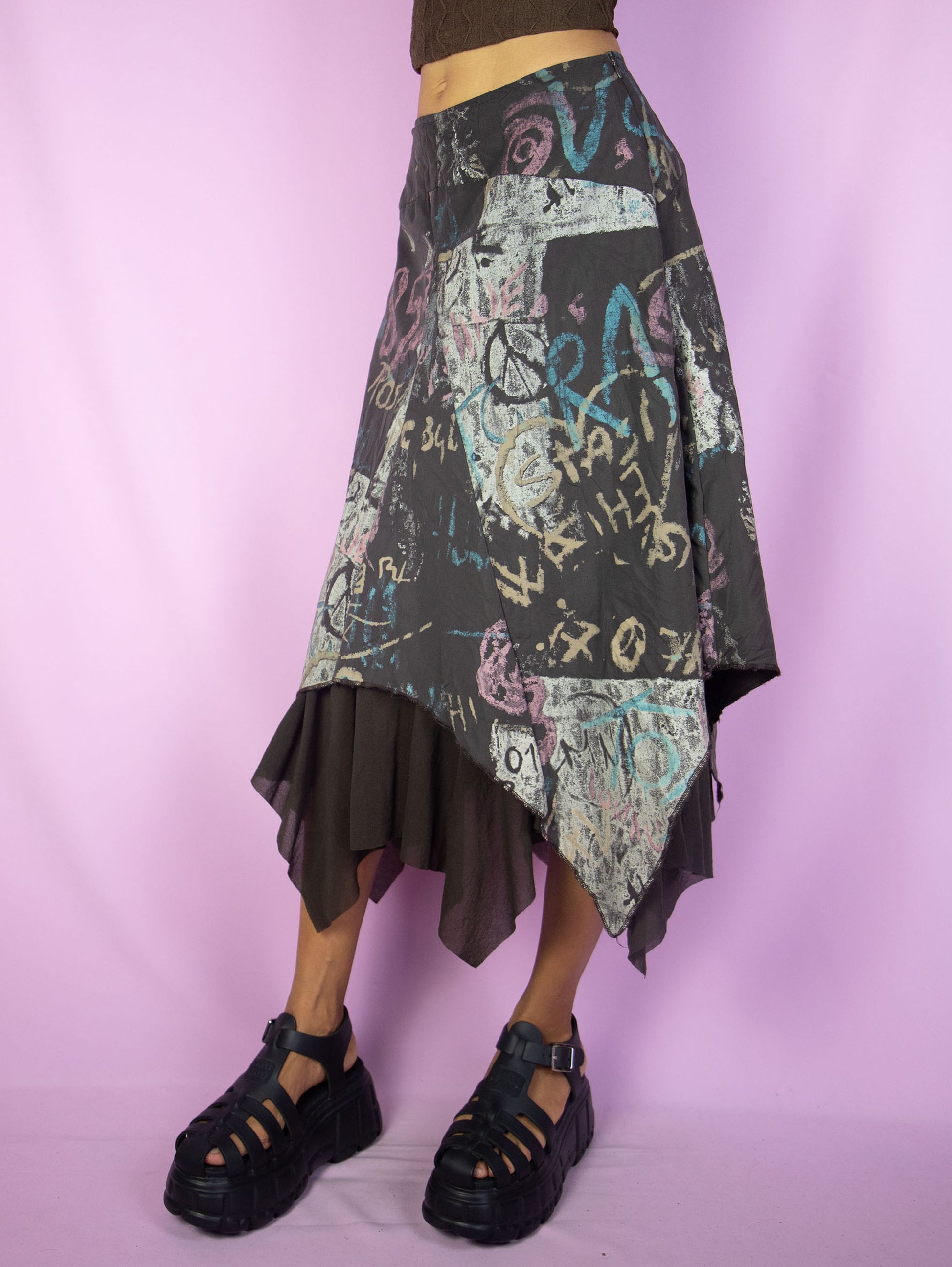 The Y2K Layered Asymmetric Midi Skirt is a vintage 2000s cyber subversive party style dark brown abstract printed skirt with a pointed asymmetrical semi-sheer mesh hem and side zipper closure. Made in France.