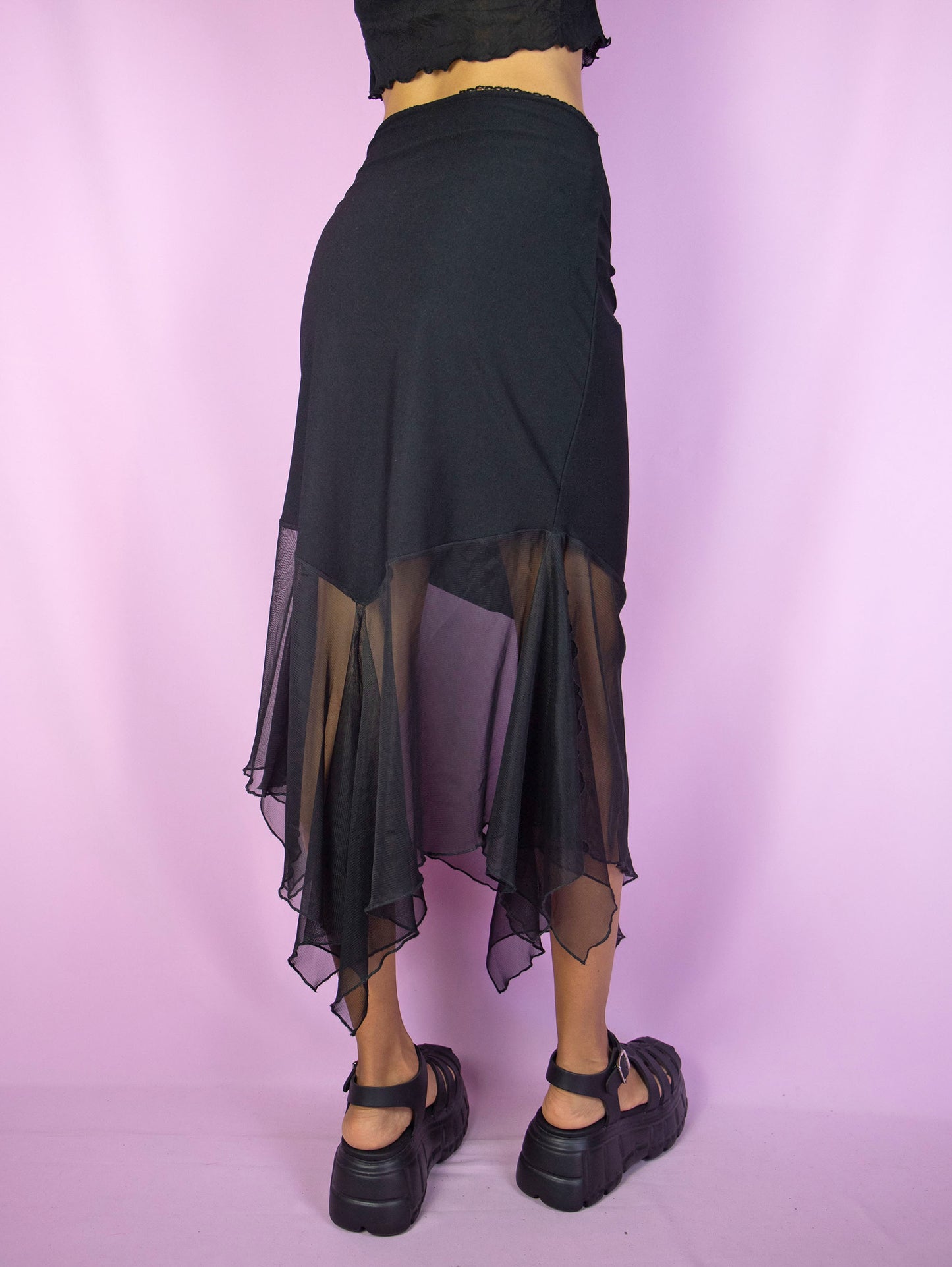 The Y2K Black Mesh Midi Skirt is a vintage 2000s fairy goth subversive party style skirt with a pointed asymmetrical semi-sheer hem and an elastic waist.