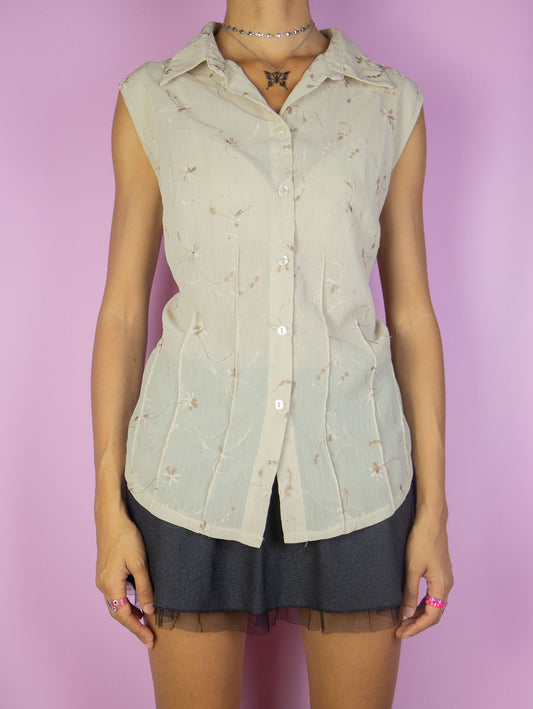 The Vintage 90s Boho Beige Sleeveless Blouse is a summer shirt with light brown embroidered floral details, a collar and buttons.
