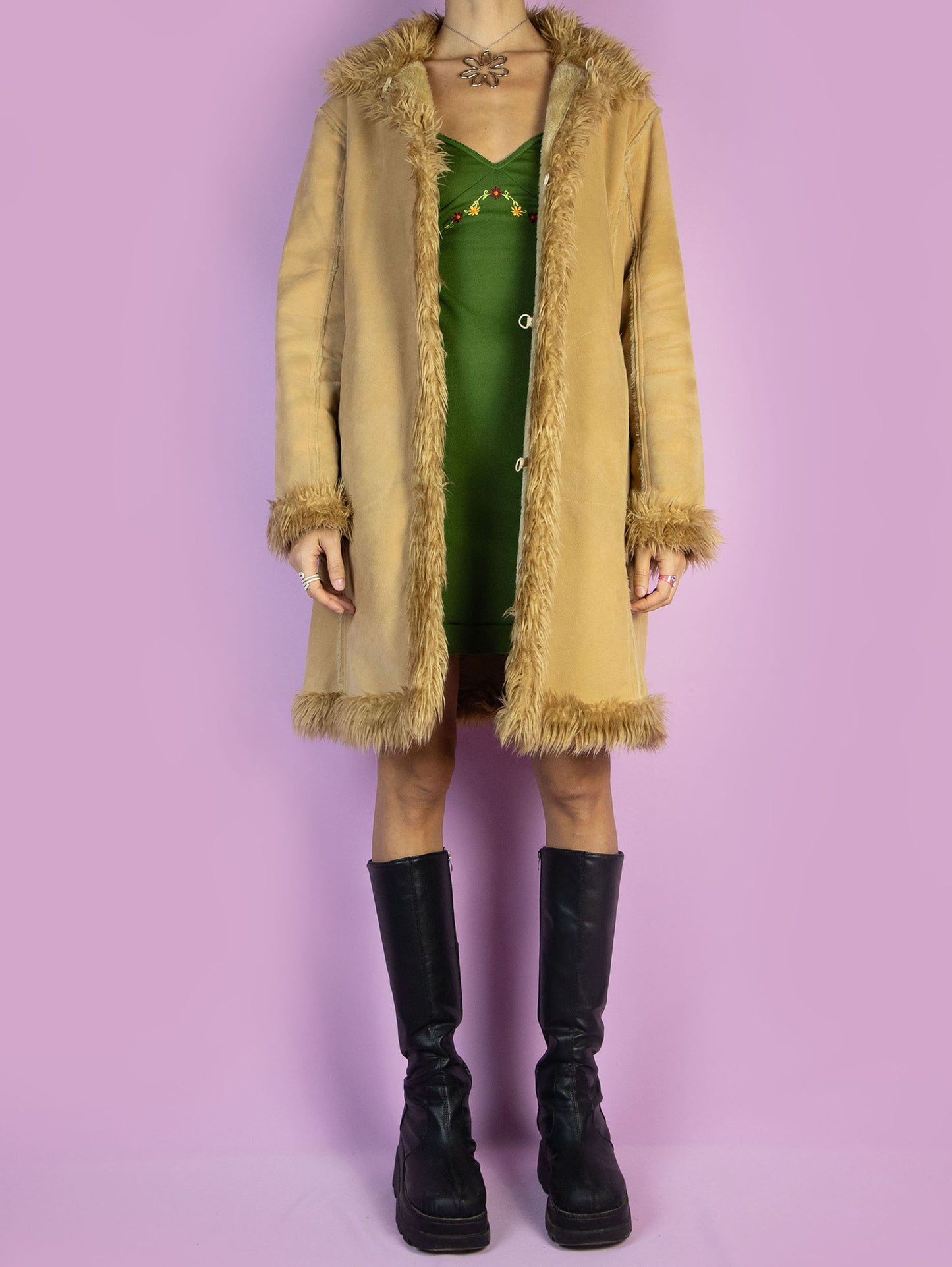 The Y2K Penny Lane Beige Coat is a vintage light brown beige faux suede coat with faux fur interior, collar, and cuffs. It also has pockets and a hook closure. Boho fairy grunge 2000s afghan-inspired winter statement jacket.