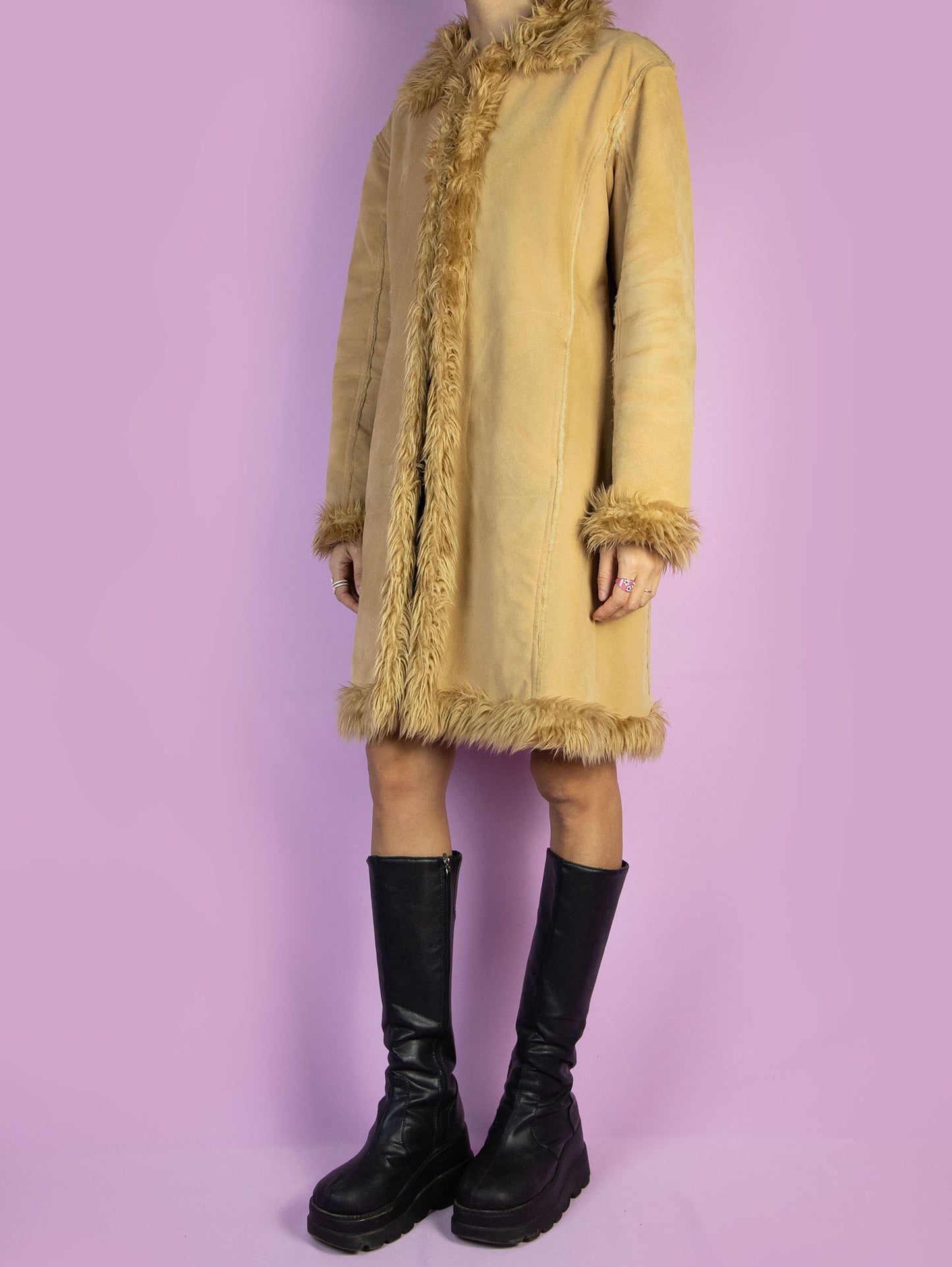 The Y2K Penny Lane Beige Coat is a vintage light brown beige faux suede coat with faux fur interior, collar, and cuffs. It also has pockets and a hook closure. Boho fairy grunge 2000s afghan-inspired winter statement jacket.