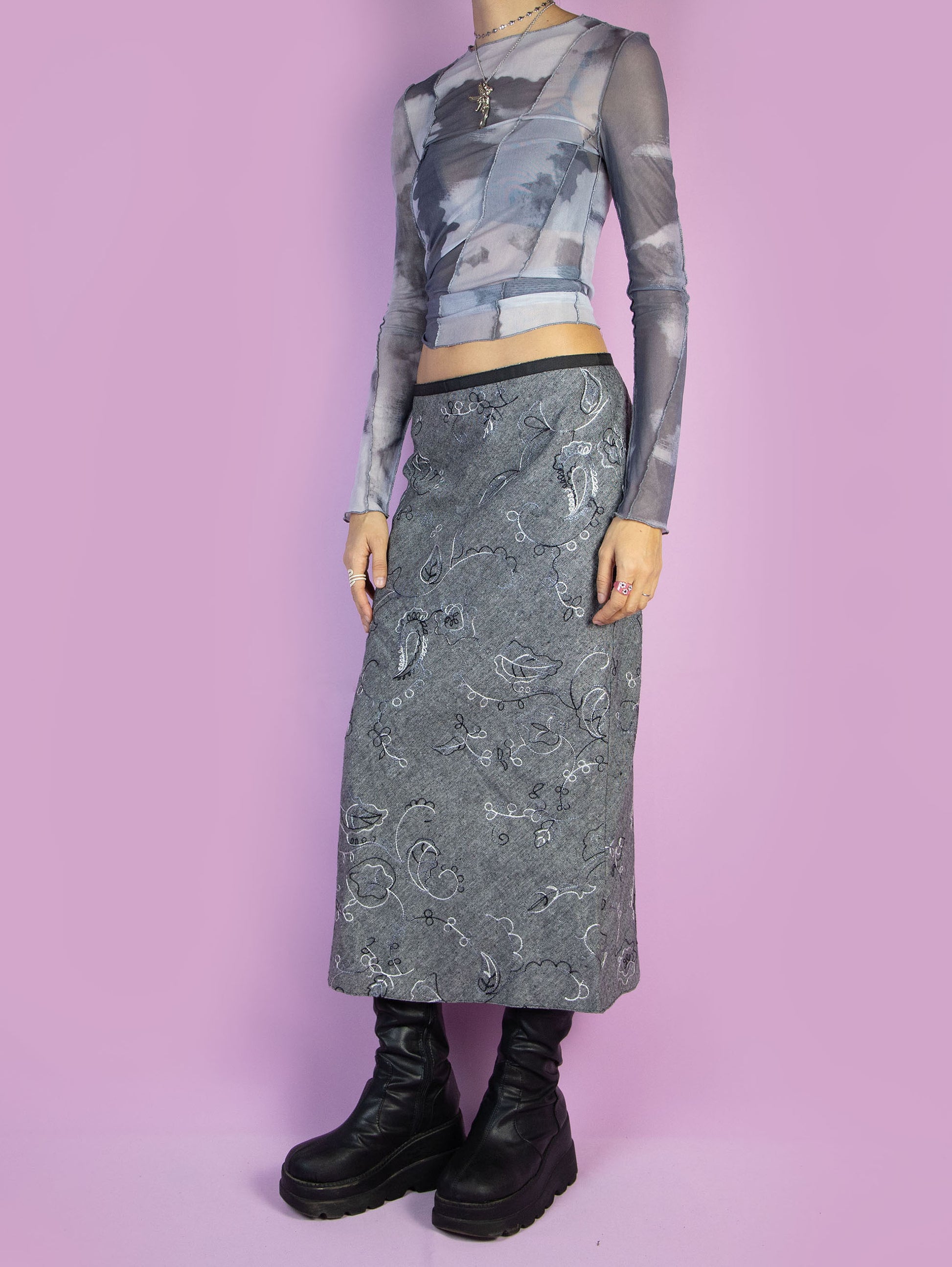 The Vintage 90s Gray Trumpet Midi Skirt is a boho fairy grunge inspired knitted skirt with embroidered floral paisley details and a back zipper closure. Excellent vintage condition.