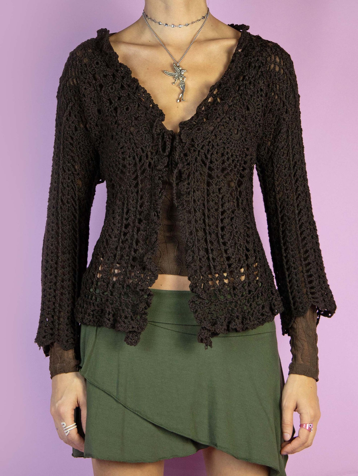 The Y2K Brown Crochet Bolero Shrug is a vintage dark brown three-quarter sleeve bolero that ties at the front. Boho fairy grunge 2000s knit cardigan.