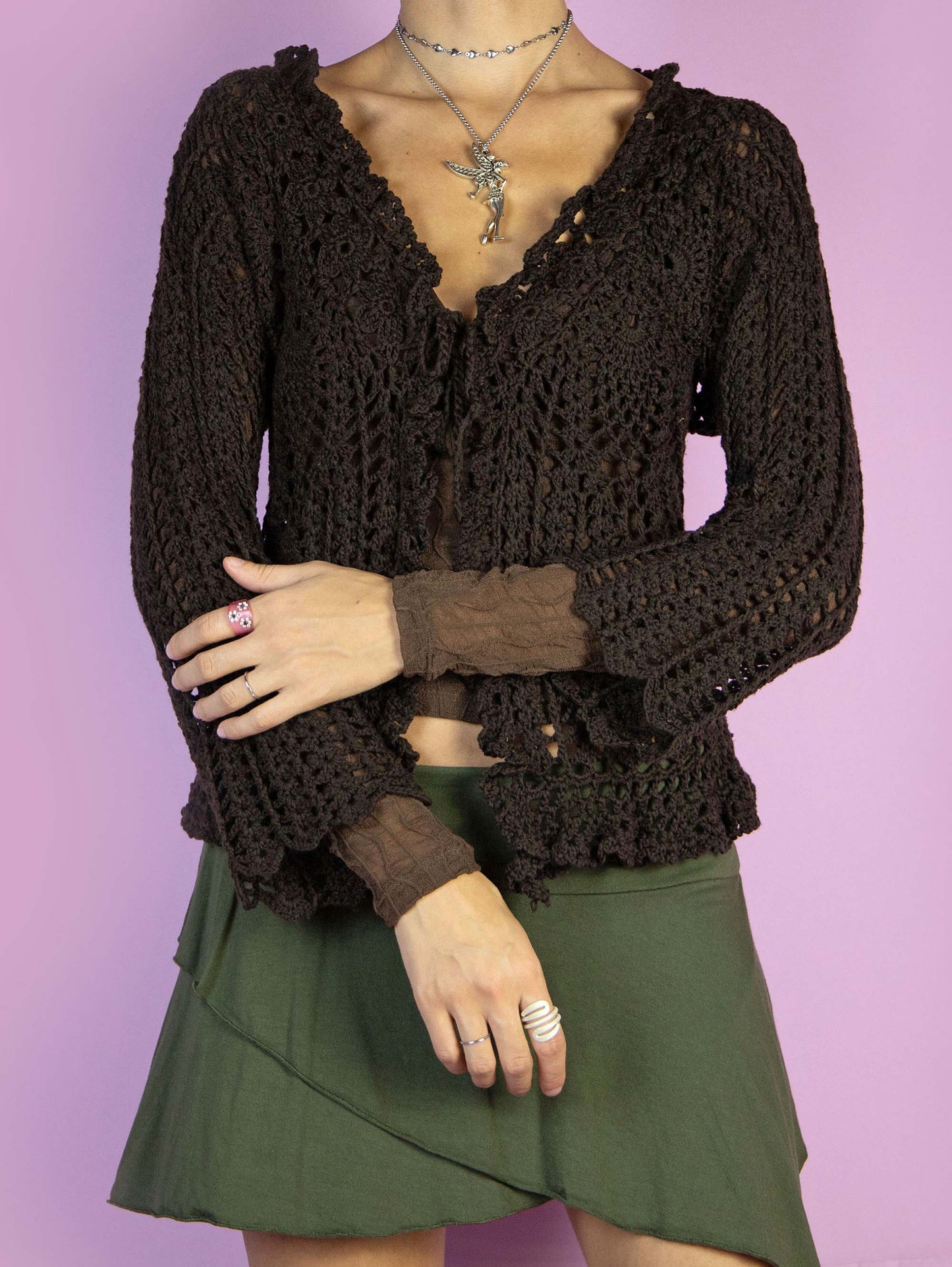 The Y2K Brown Crochet Bolero Shrug is a vintage dark brown three-quarter sleeve bolero that ties at the front. Boho fairy grunge 2000s knit cardigan.