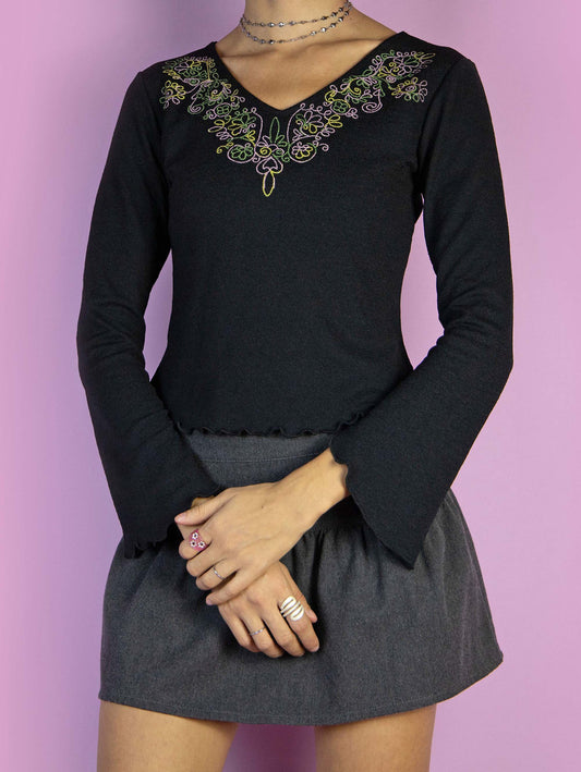 The Vintage 90s Boho Black Top is a black bell-sleeved shirt with a V-neck and floral details. Fairy grunge whimsygoth 1990s blouse.