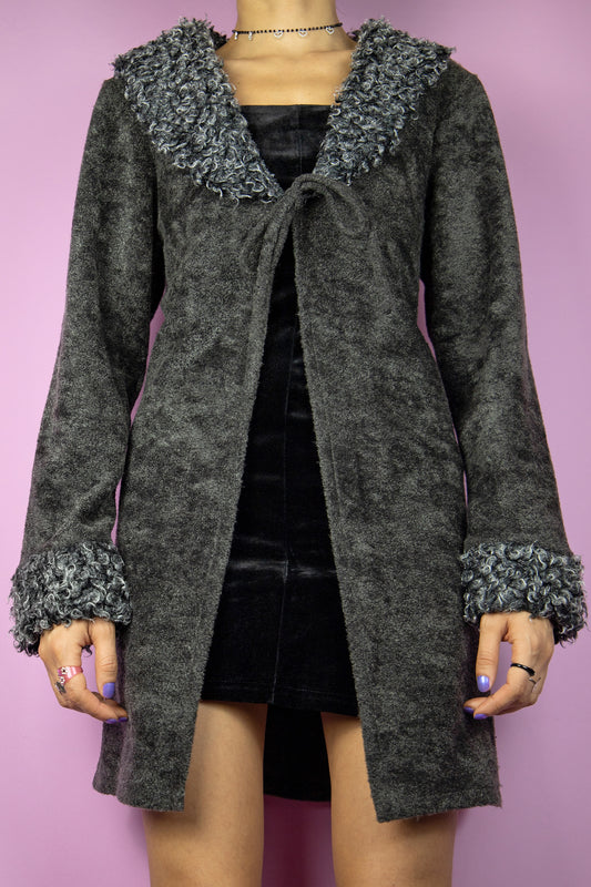 The Y2K Penny Lane Duster Jacket is a vintage gray jacket featuring a faux fur collar and cuffs, fastened with a tie at the front. Cyber whimsygoth 2000s coat.
