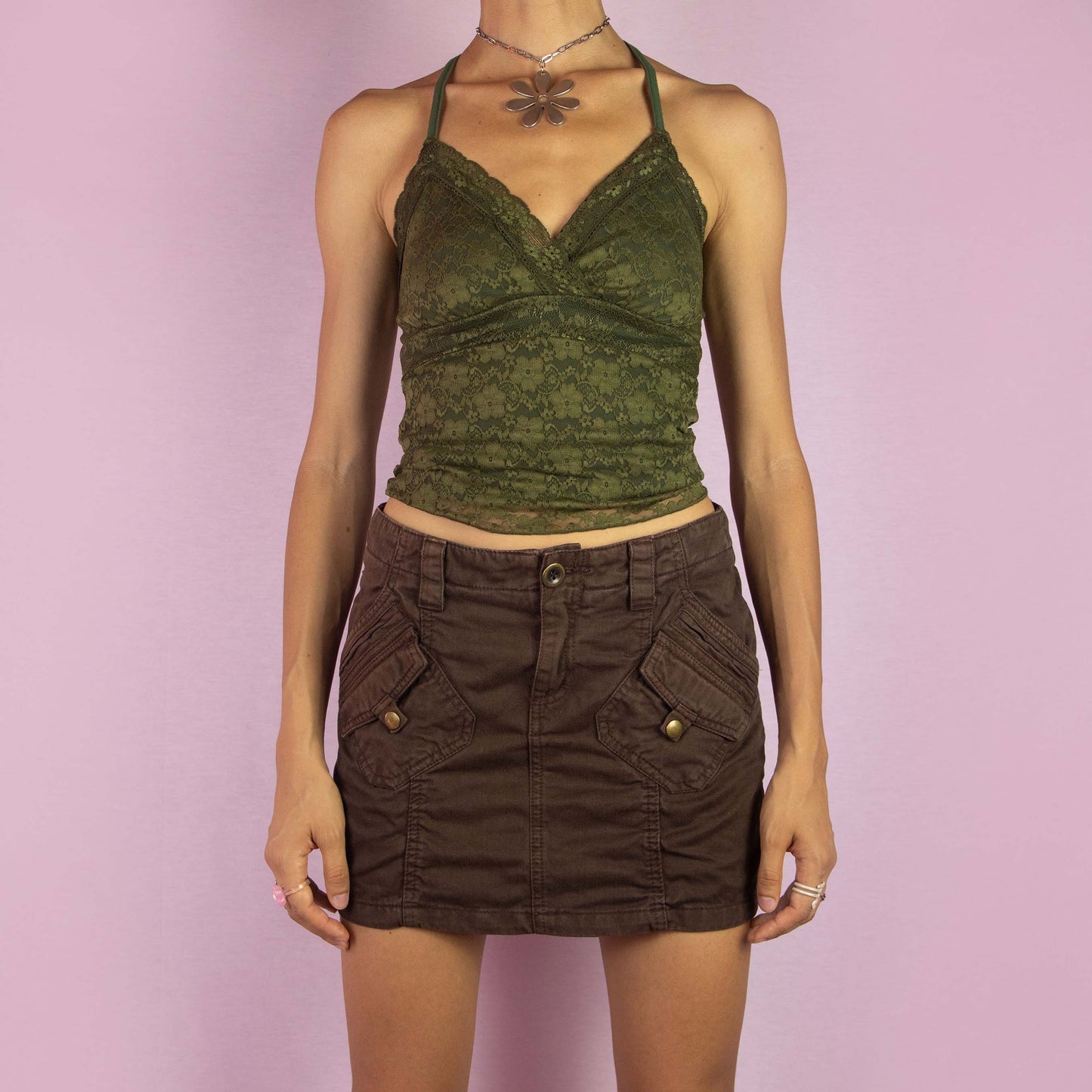 The Y2K Brown Cargo Mini Skirt is a vintage 2000s piece featuring a low-rise fit and a mini length silhouette. Made from brown cotton, the skirt is designed with cargo-style pockets, and button flap details. It includes a front button and zipper closure, making it perfect for casual wear and summer outings.