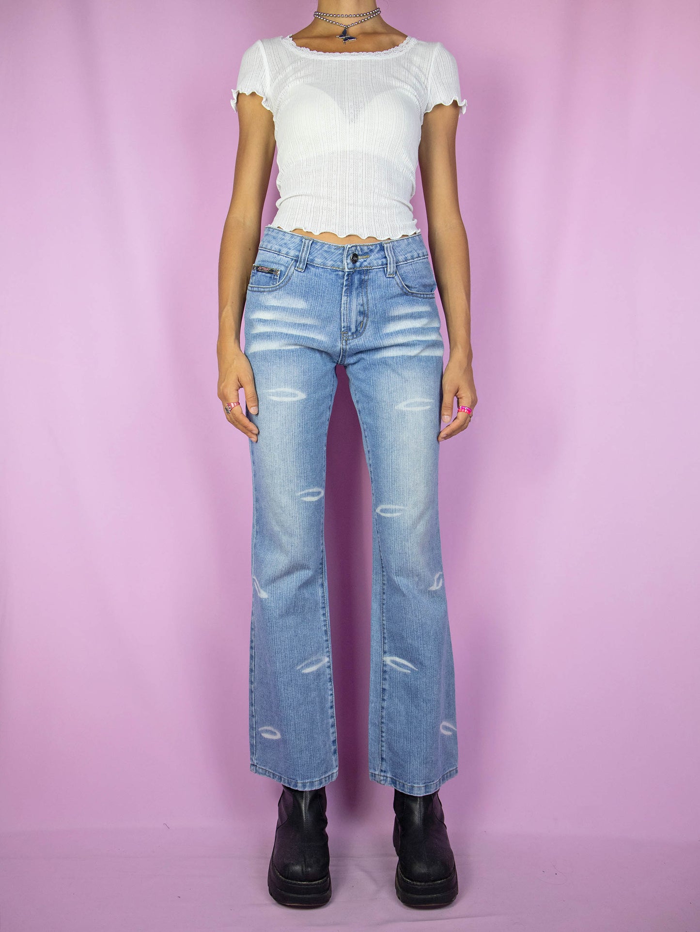 The Y2K Cyber Mid Rise Jeans are vintage 2000s bootcut straight-leg denim pants with bleached details.