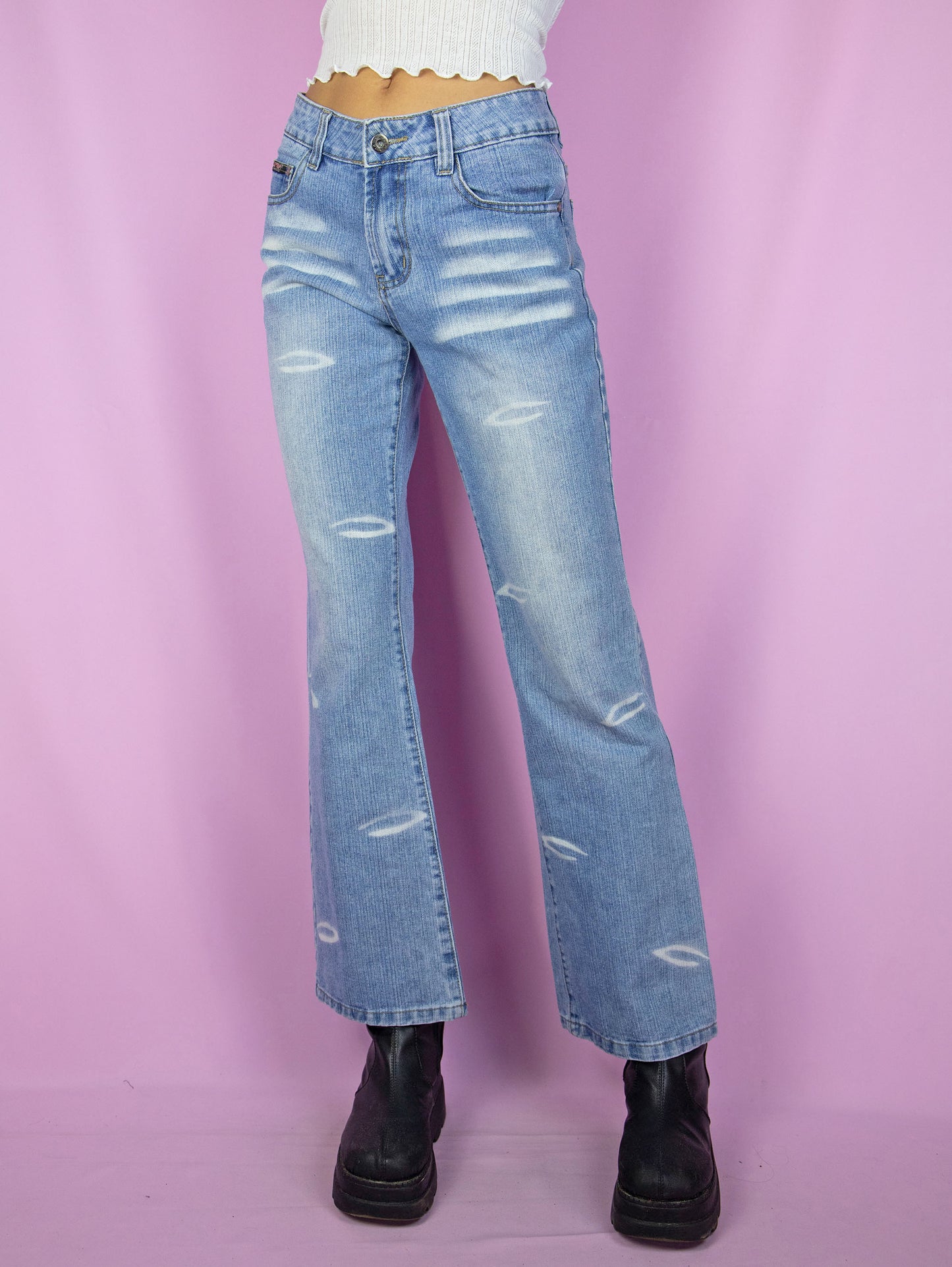 The Y2K Cyber Mid Rise Jeans are vintage 2000s bootcut straight-leg denim pants with bleached details.