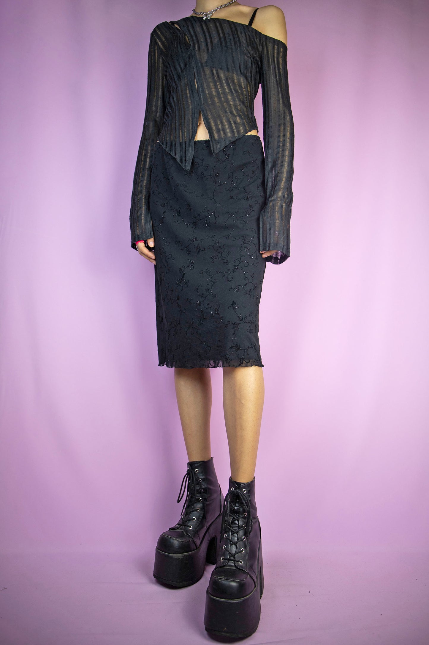 The Vintage Y2K Black Floral Mesh Skirt is a black floral mesh skirt featuring glitter details, a lettuce hem, and an elastic waist. This super cute fairy grunge goth mini skirt captures the essence of the 2000s.