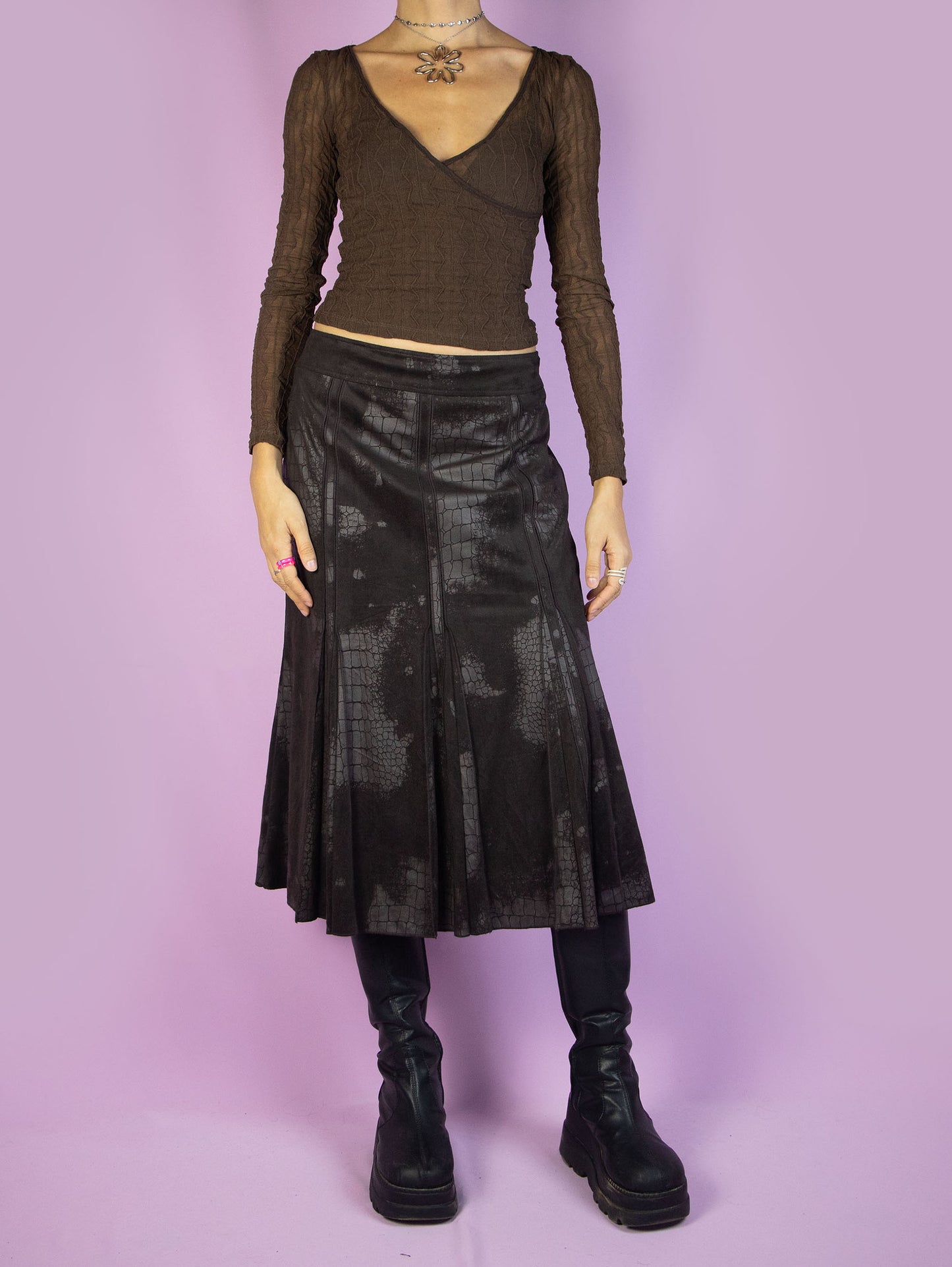 The Y2K Dark Brown Midi Skirt is a vintage 2000s trumpet maxi skirt crafted from faux suede, featuring an animal print pattern and a side zipper closure. Its elegant design makes it perfect for both casual wear and special events. Excellent vintage condition.