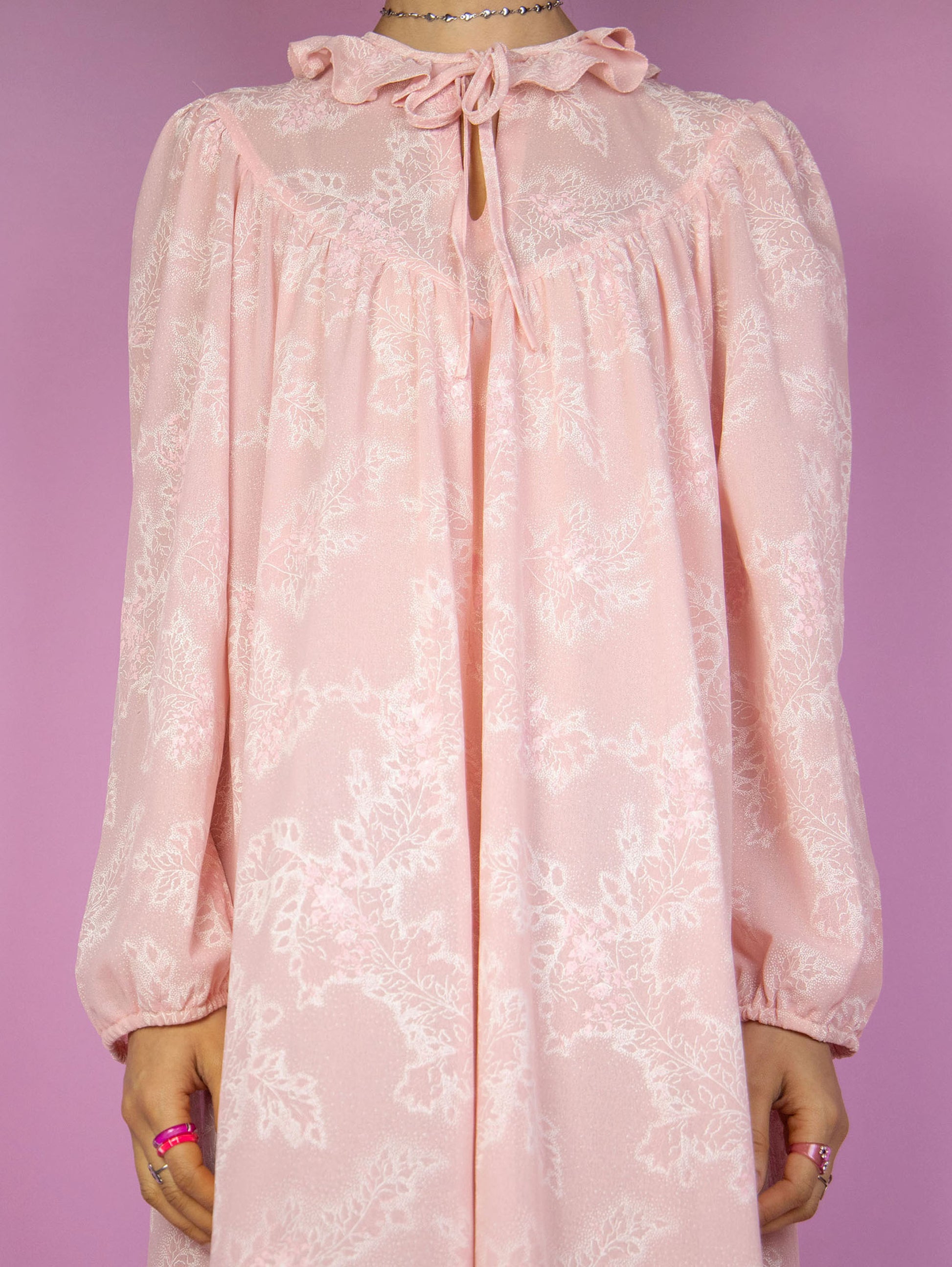 The Vintage 90s Pink Floral Nightgown Dress is a romantic cottagecore-inspired pastel pink puff sleeve midi night dress lounge sleepwear with a tied-up front ruffled neckline.