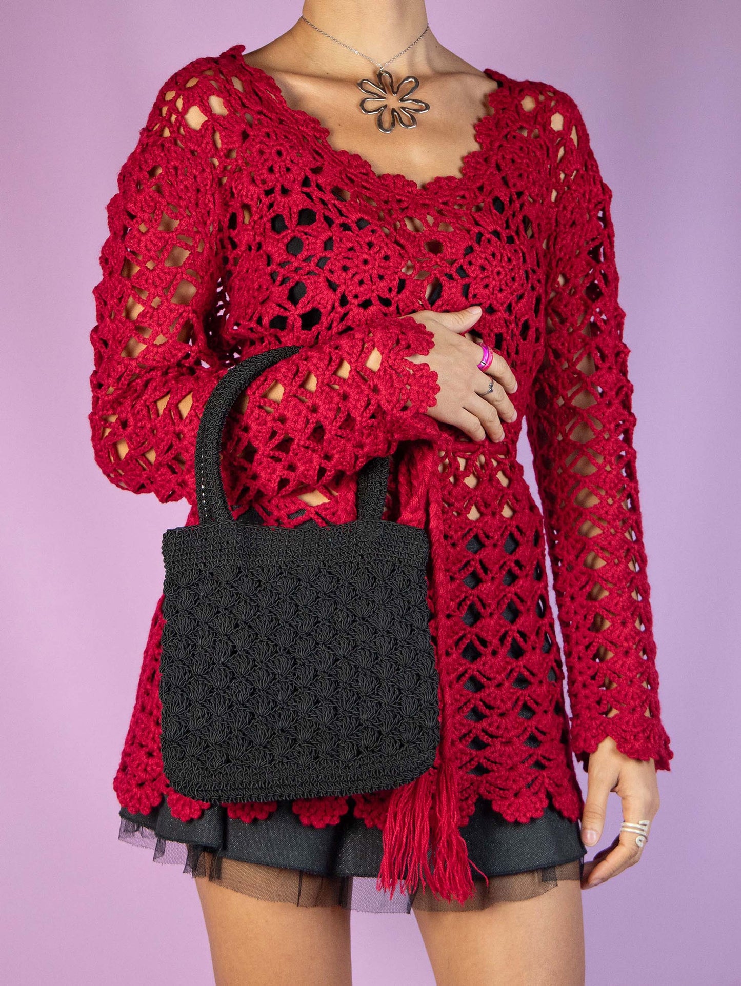 The Y2K Black Crochet Mini Bag is a vintage 2000s boho party style handbag with a top handle, crafted in a crochet-style with a zipper closure.