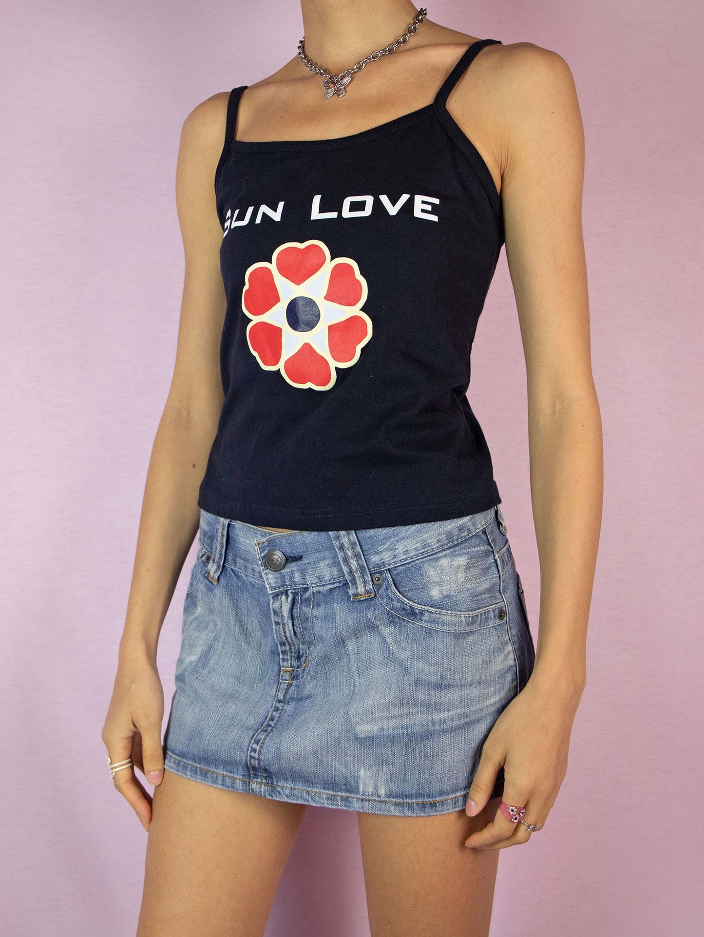 The Y2K Graphic Tank Top is a vintage 2000s dark navy, almost black cami top, featuring a bold graphic print. Perfect for any beach or summer look. Made in Italy.