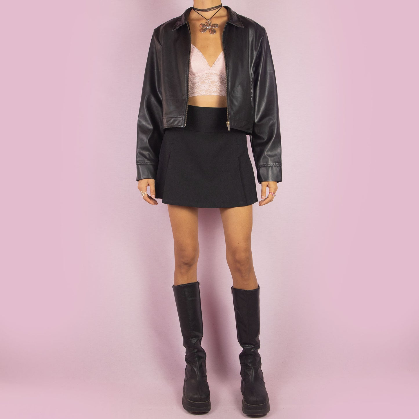 The Y2K Black Faux Leather Jacket is a vintage 2000s sleek and minimalist piece featuring a zip-up front, classic collar, shoulder pads, cropped cut, and a smooth faux leather finish. Ideal for casual fall looks or a night out.