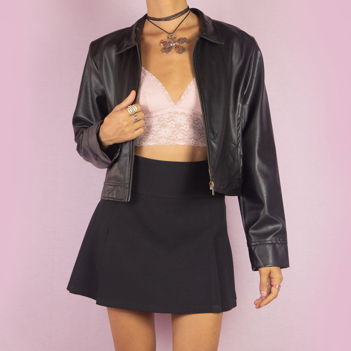 The Y2K Black Faux Leather Jacket is a vintage 2000s sleek and minimalist piece featuring a zip-up front, classic collar, shoulder pads, cropped cut, and a smooth faux leather finish. Ideal for casual fall looks or a night out.