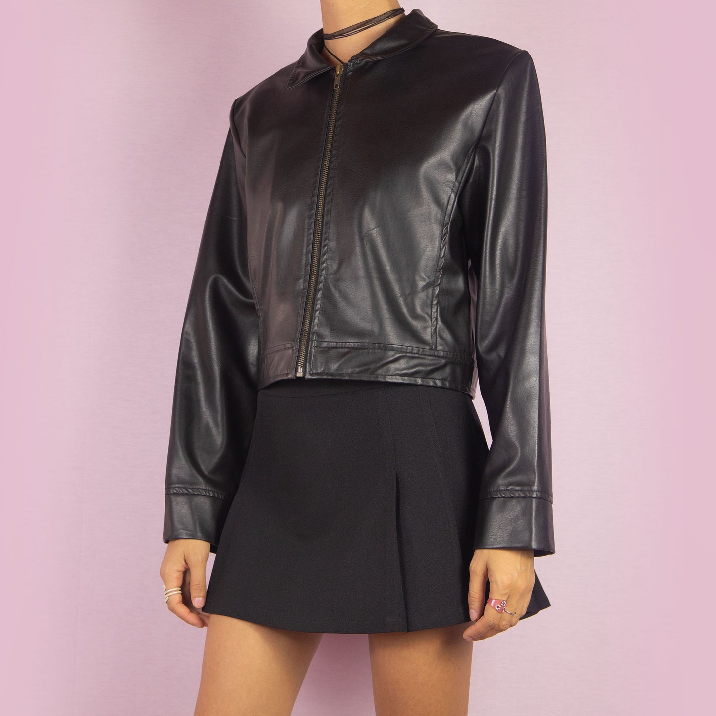 The Y2K Black Faux Leather Jacket is a vintage 2000s sleek and minimalist piece featuring a zip-up front, classic collar, shoulder pads, cropped cut, and a smooth faux leather finish. Ideal for casual fall looks or a night out.