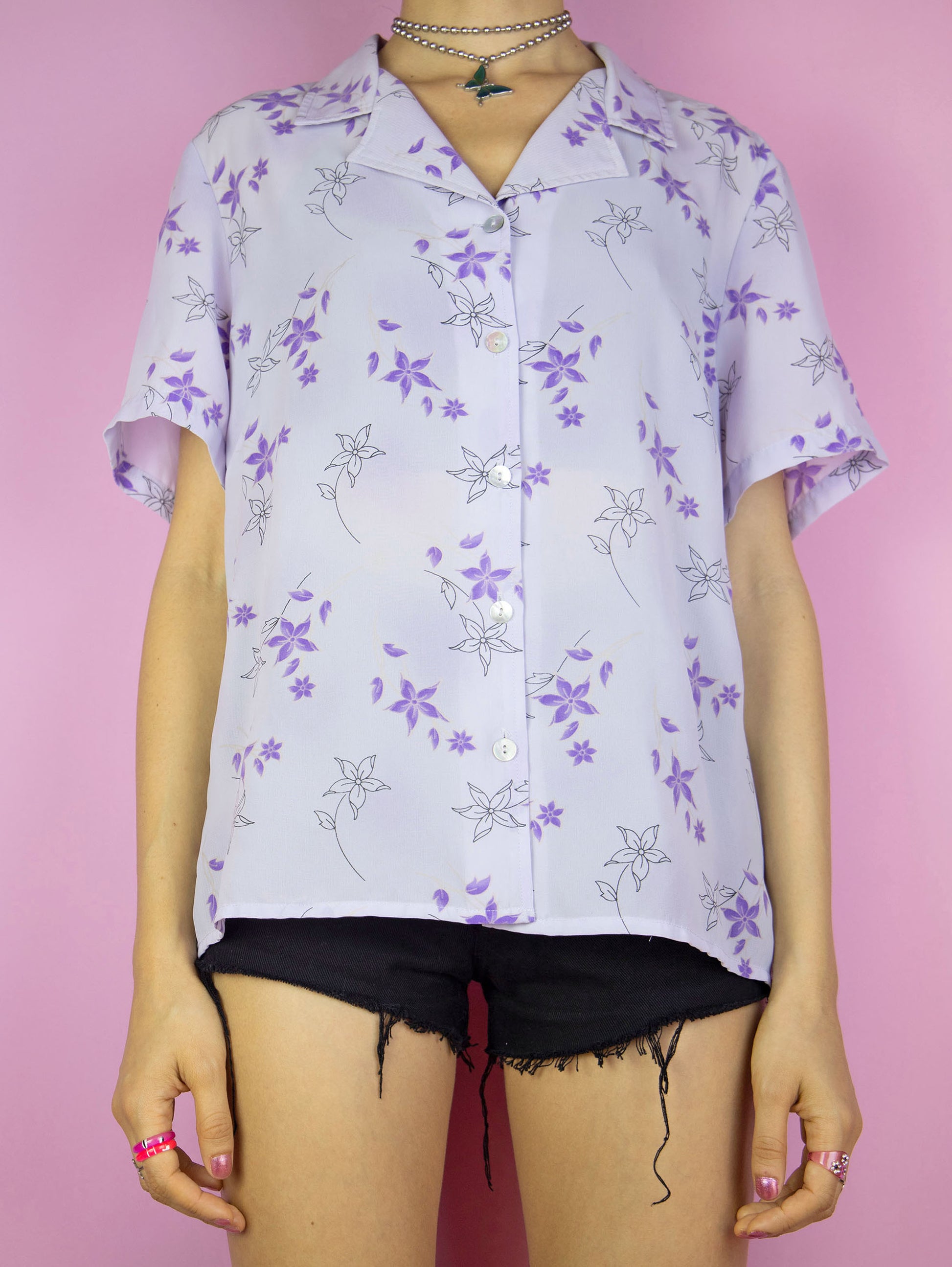 The Y2K Lilac Floral Print Blouse is a vintage 2000s boho cottagecore style light pastel purple short sleeve summer shirt with a collar and buttons.