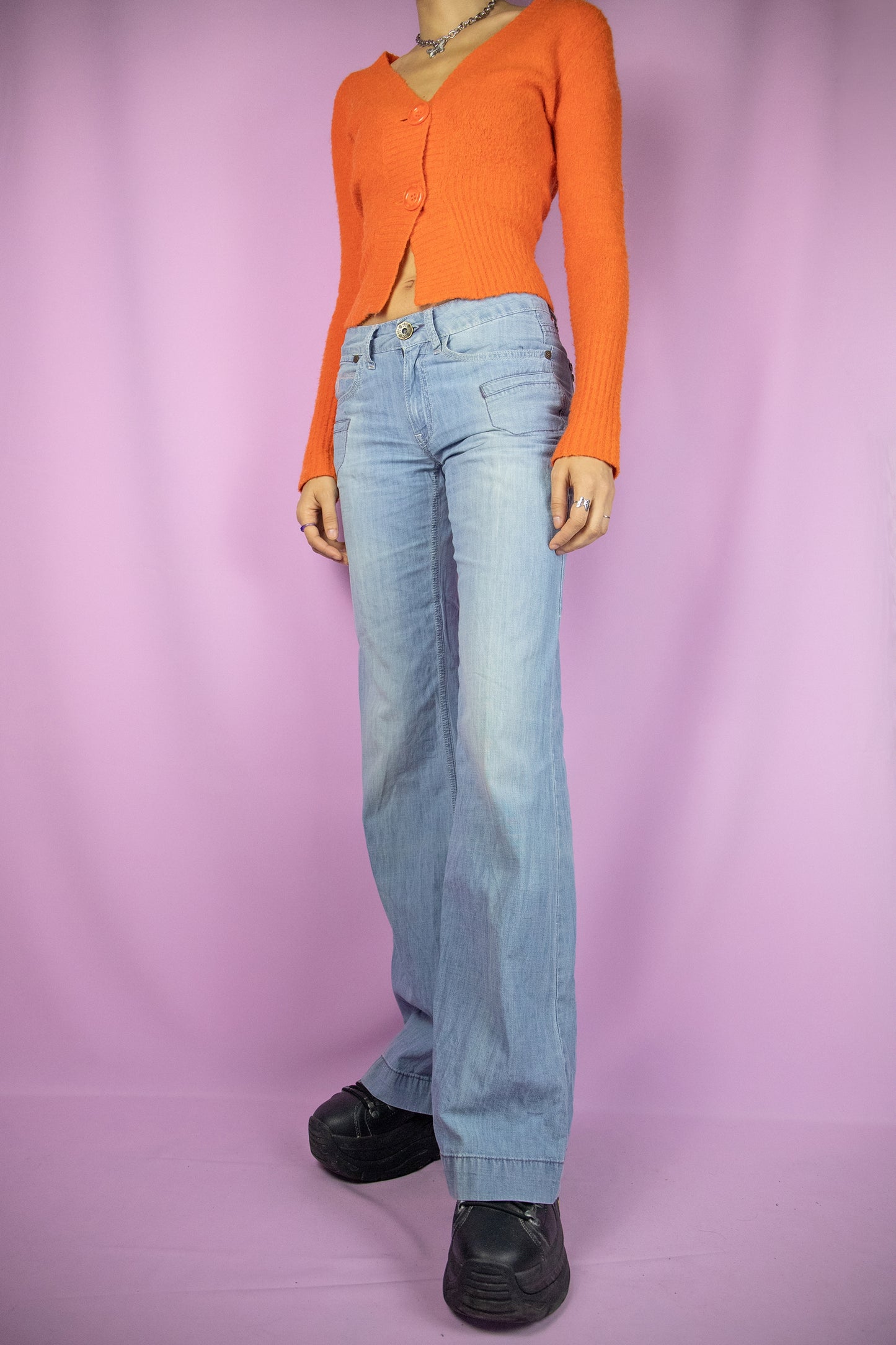 The Y2K Flare Low Rise Jeans are vintage 2000s light blue denim wide-leg pants with pockets and a zipper closure.