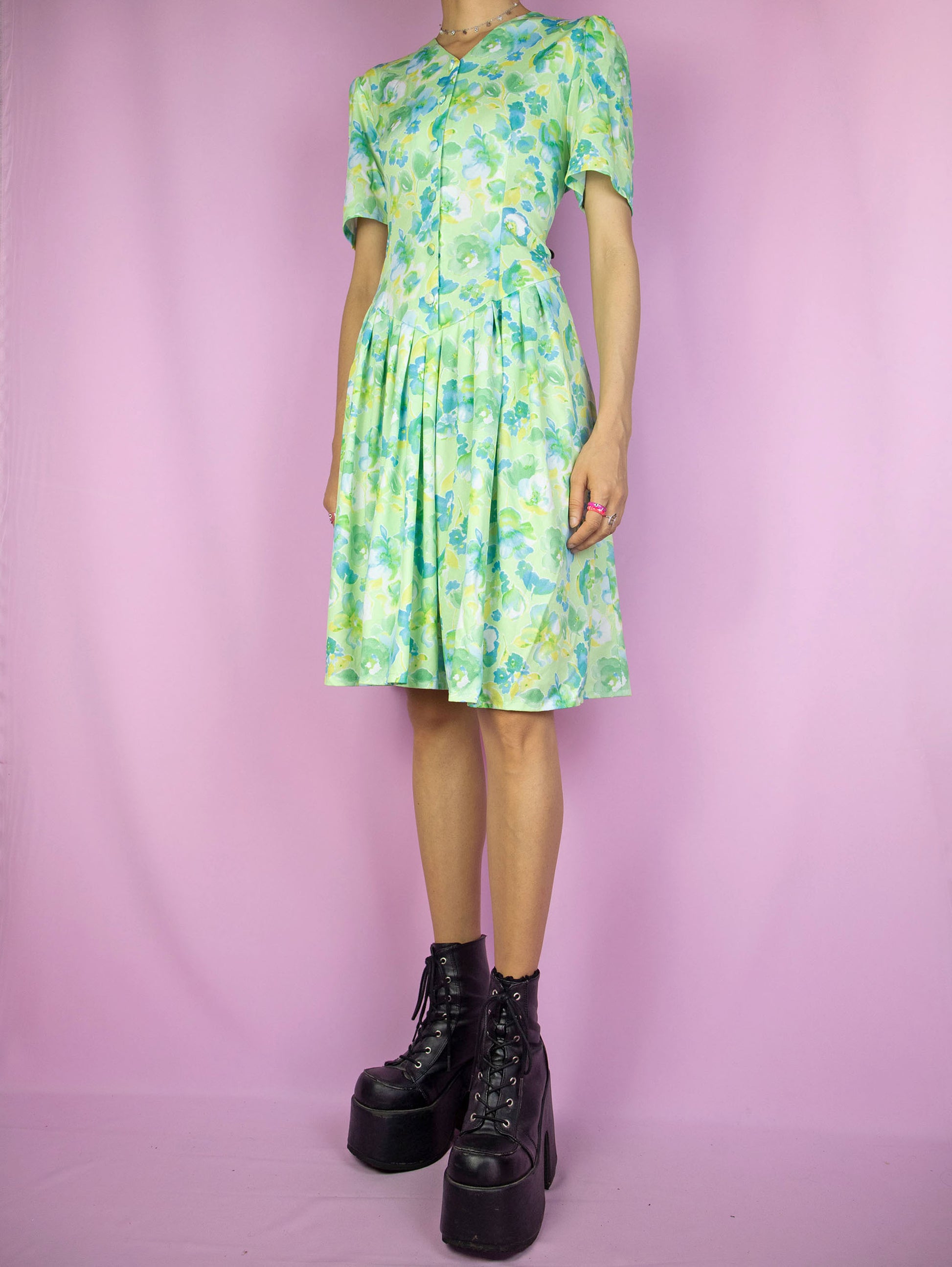 The Vintage 90s Retro Green Floral Dress is a light green blue and yellow floral short sleeve button pleated dress. Boho grunge 1990s summer mini dress.