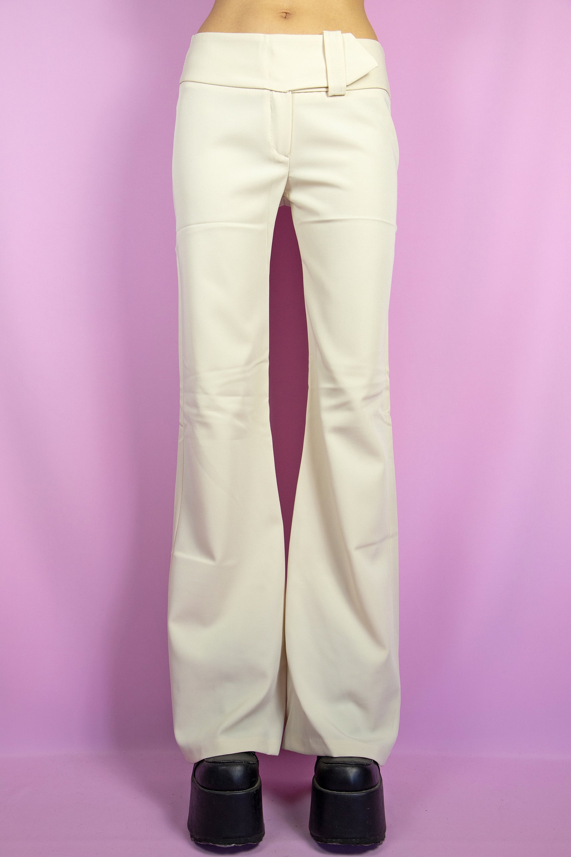 The Y2K Beige Belted Flare Pants are vintage slightly stretchy mid-rise beige flare pants with a belt detail. Cyber 2000s wide pants.