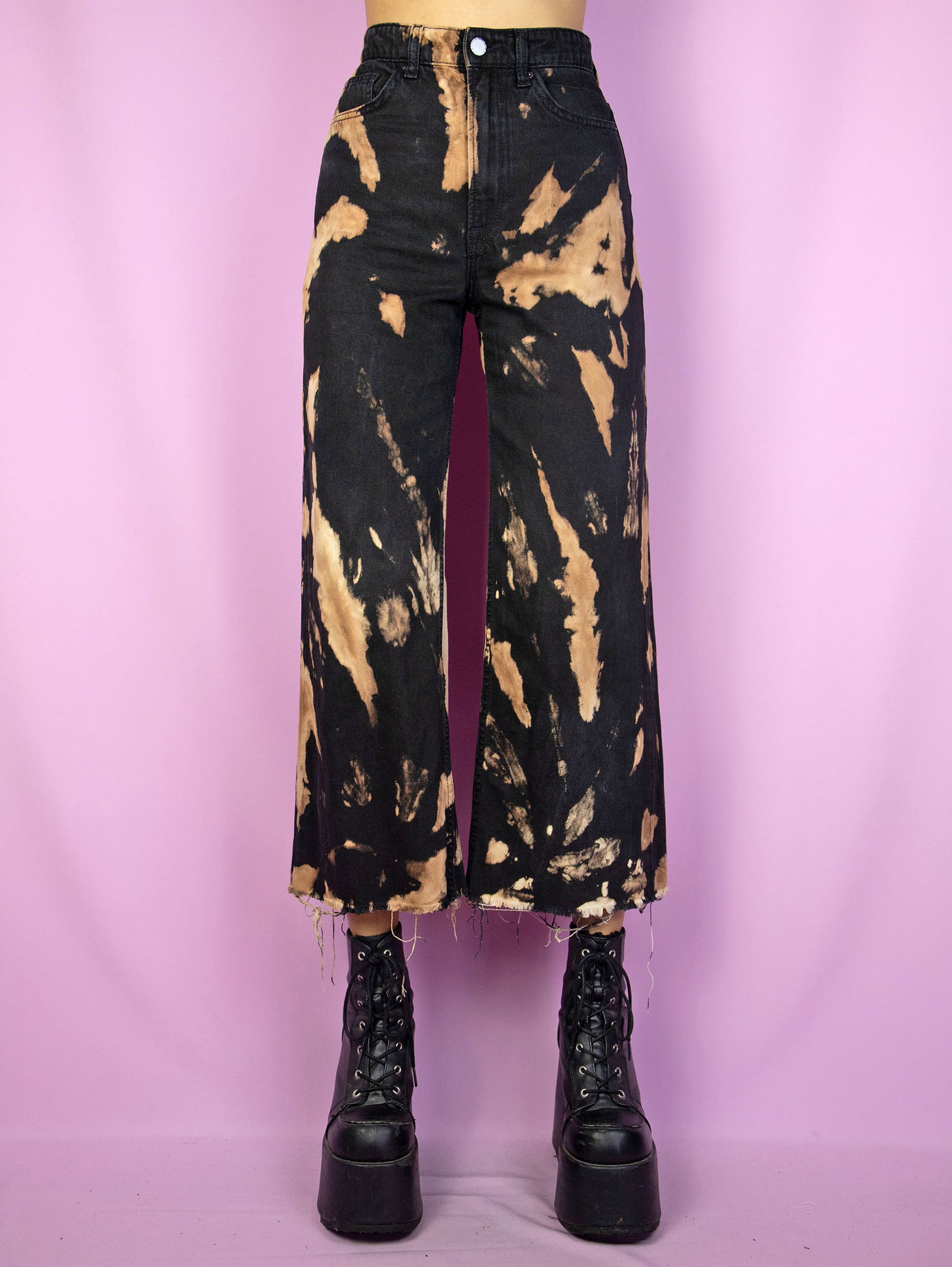 The Y2K Black Tie Dye Jeans are a vintage high waisted black bleached tie dye capri pants with a frayed hem. Cyber goth 2000s wide leg trousers.