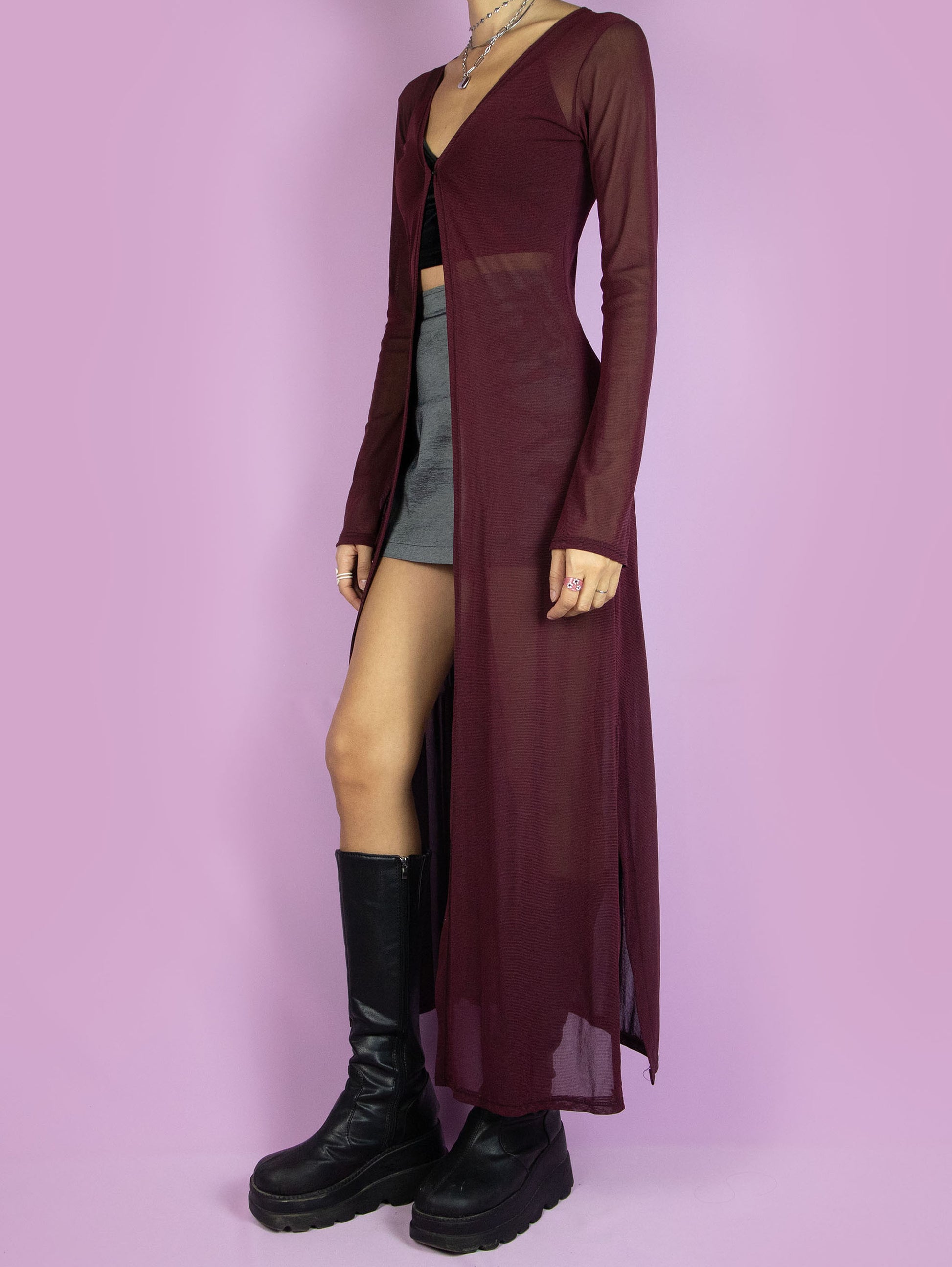 The Y2K Maroon Mesh Duster Jacket is a vintage burgundy semi-sheer mesh maxi long duster jacket with bell sleeves and a front hook closure. Cyber goth 2000s festival rave party coat.