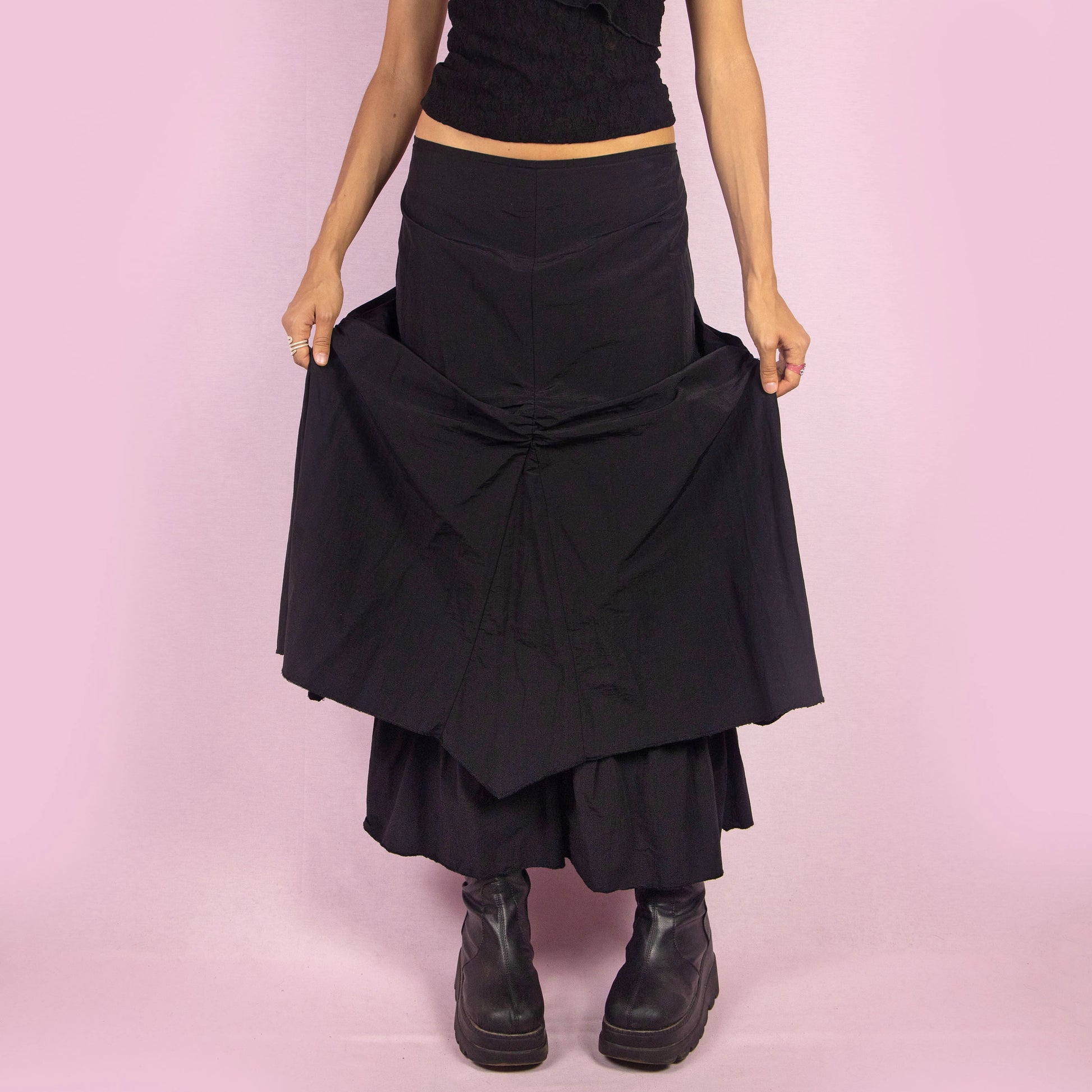 The Y2K Black Layered Midi Skirt is a vintage 2000s piece that features a unique, layered design with ruched details along the front. It includes a back zipper closure and a high-waisted fit. Perfect for both casual and night-out outfits.