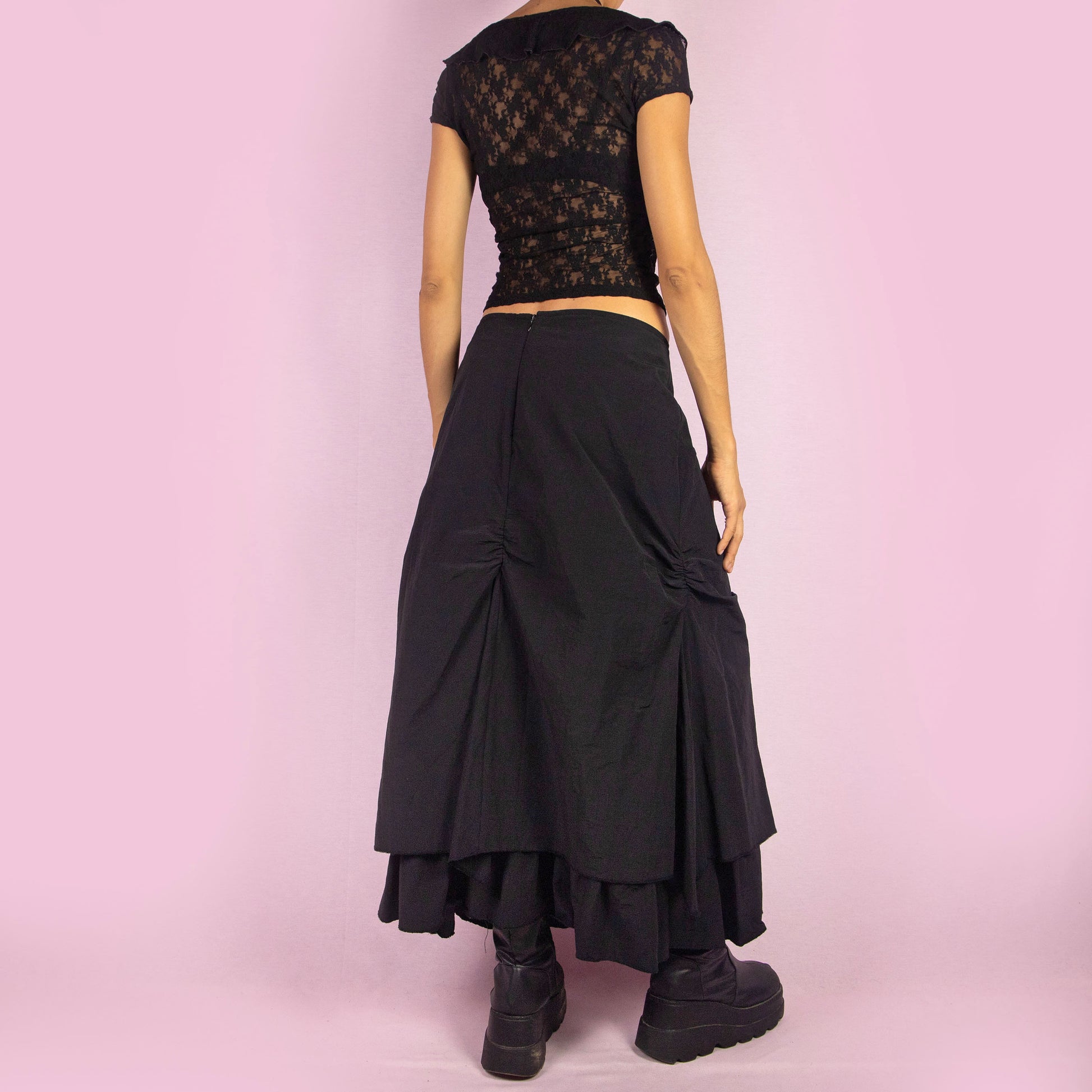 The Y2K Black Layered Midi Skirt is a vintage 2000s piece that features a unique, layered design with ruched details along the front. It includes a back zipper closure and a high-waisted fit. Perfect for both casual and night-out outfits.