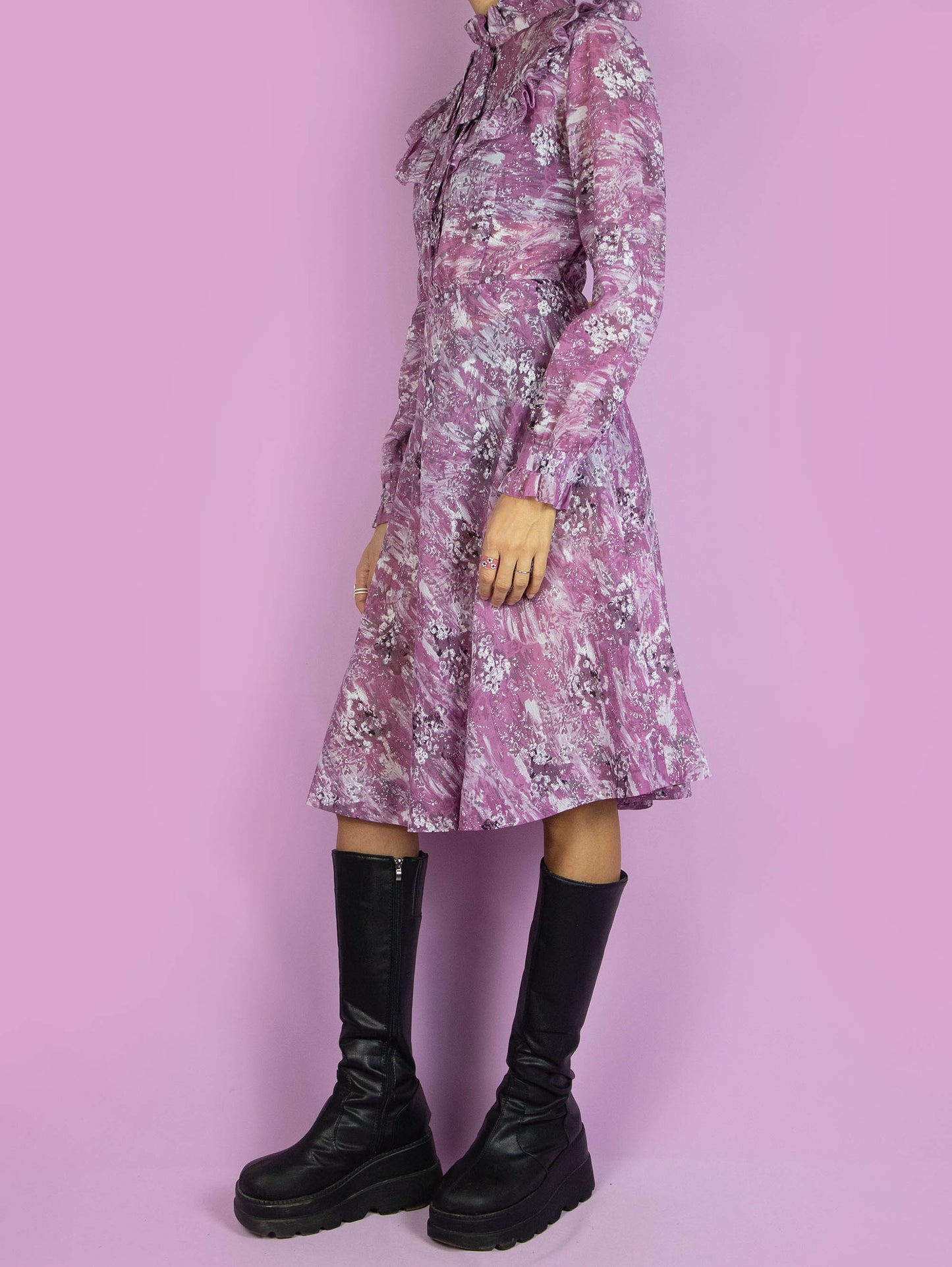 The Vintage 90s Purple Ruffle Collar Dress is a semi-sheer abstract purple dress with long sleeves, buttons, ruffles, and a bow at the collar. Boho retro 1990s romantic midi dress.