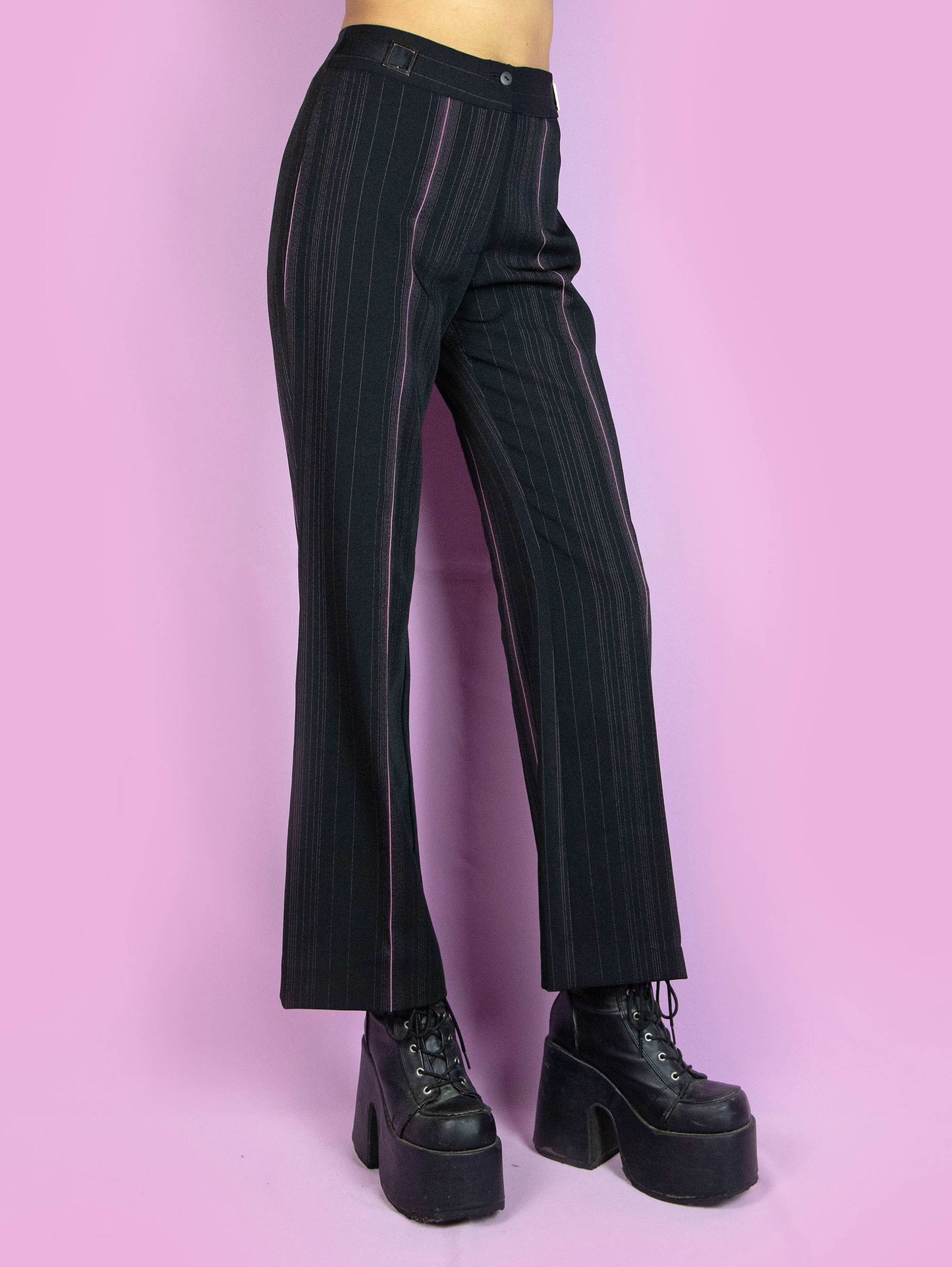 The Y2K Black Pinstripe Trousers are vintage high-waisted straight black and pink pinstripe pants, slightly elastic, with pleats and a front zipper closure. Elegant tailored style 2000s office pleated striped trousers.