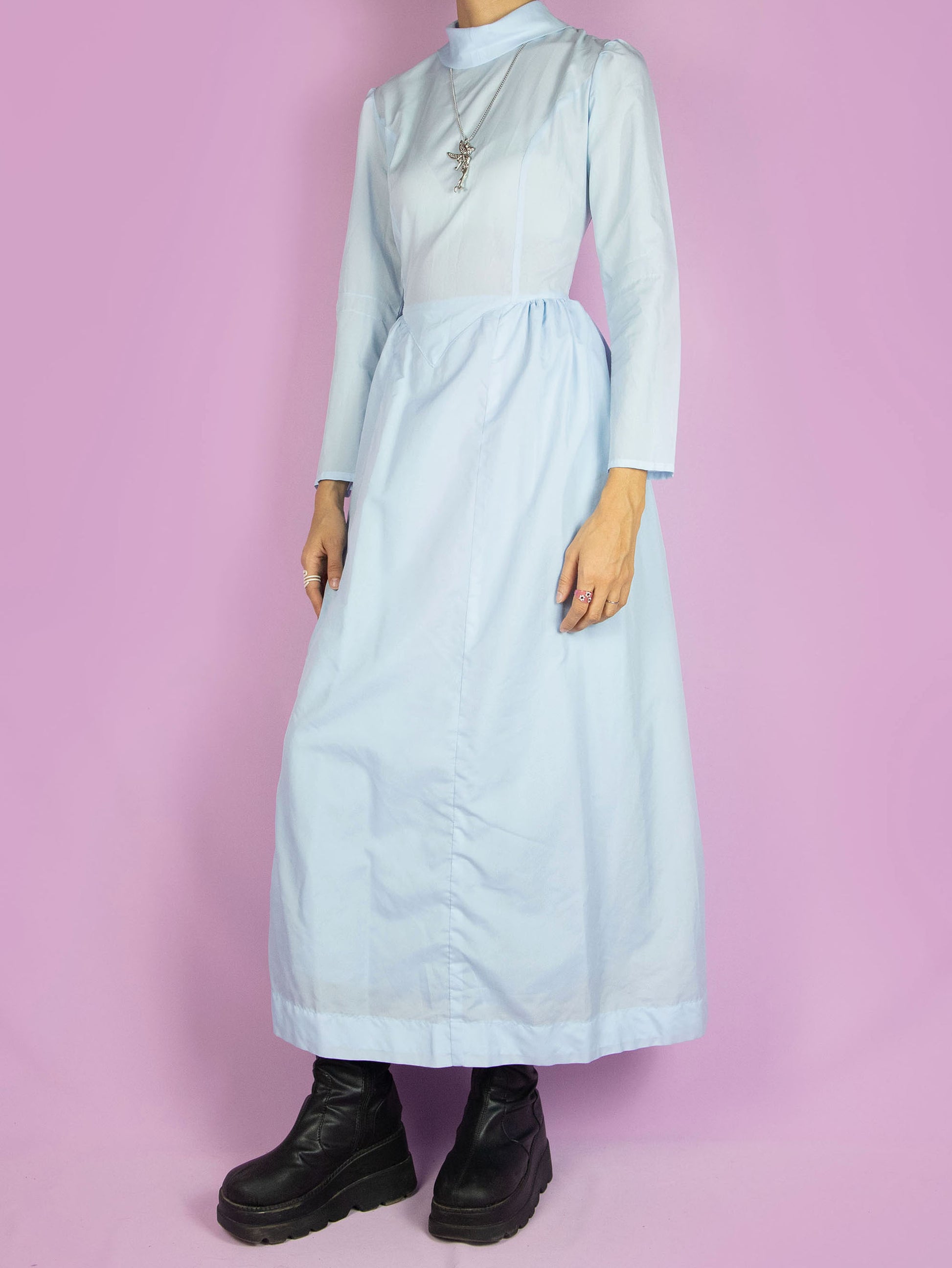 The Vintage 70s Cottage Prairie Maxi Dress is a light pastel blue long-sleeved dress with a collar and a zipper closure at the back. Country western inspired 1970s midi dress.
