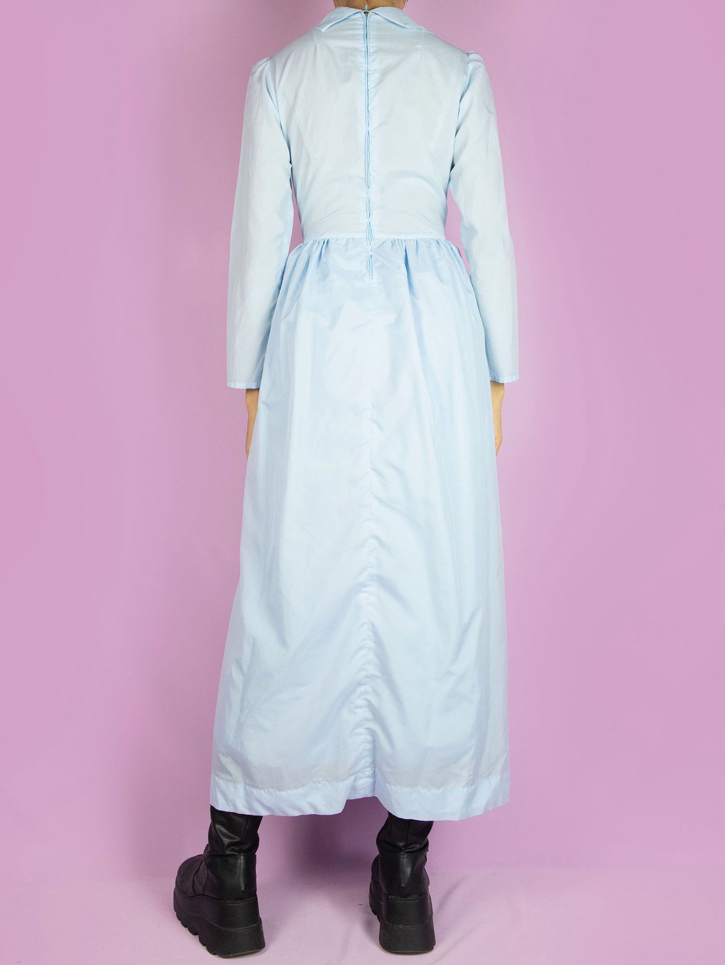 The Vintage 70s Cottage Prairie Maxi Dress is a light pastel blue long-sleeved dress with a collar and a zipper closure at the back. Country western inspired 1970s midi dress.