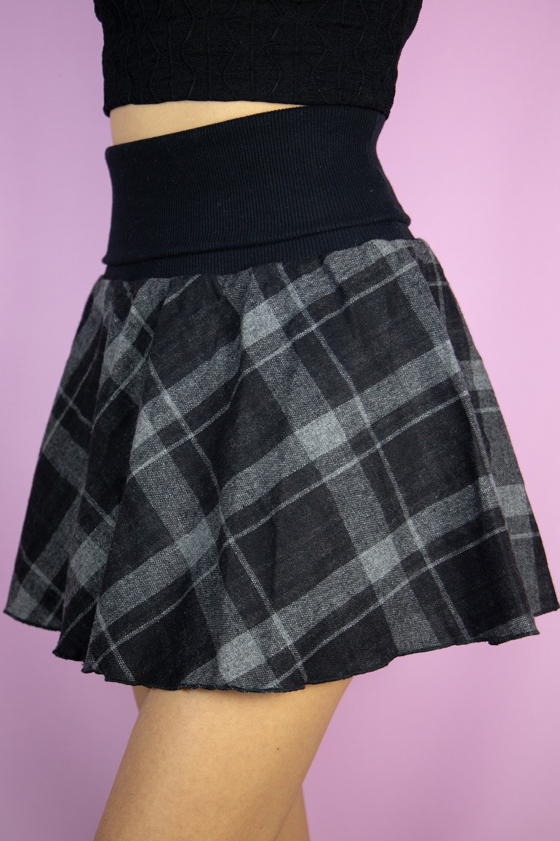 The Y2K Black Plaid Mini Skirt is a vintage black and gray check knit skirt with an elasticated ribbed waist. Fairy grunge 2000s goth mini skirt.