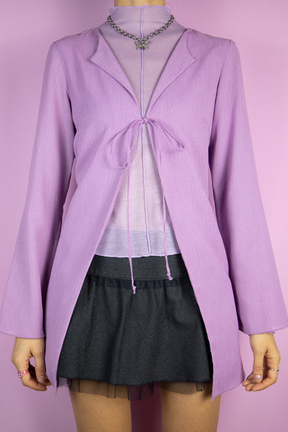 The Vintage 90’s Lilac Tie Front Top is a pastel purple blouse with flared sleeves and a front tie. It looks adorable when worn oversized. This lovely piece embodies the gorgeous fairy grunge style of the 1990s, much like a duster jacket.