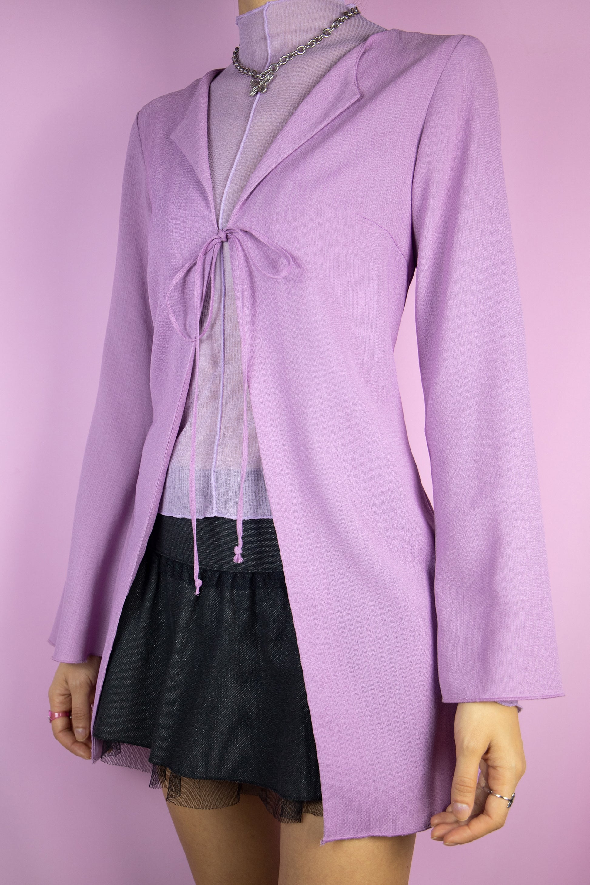 The Y2K Purple Duster Jacket is a vintage lilac top that ties at the front and has bell sleeves. Boho romantic 2000s bolero jacket.