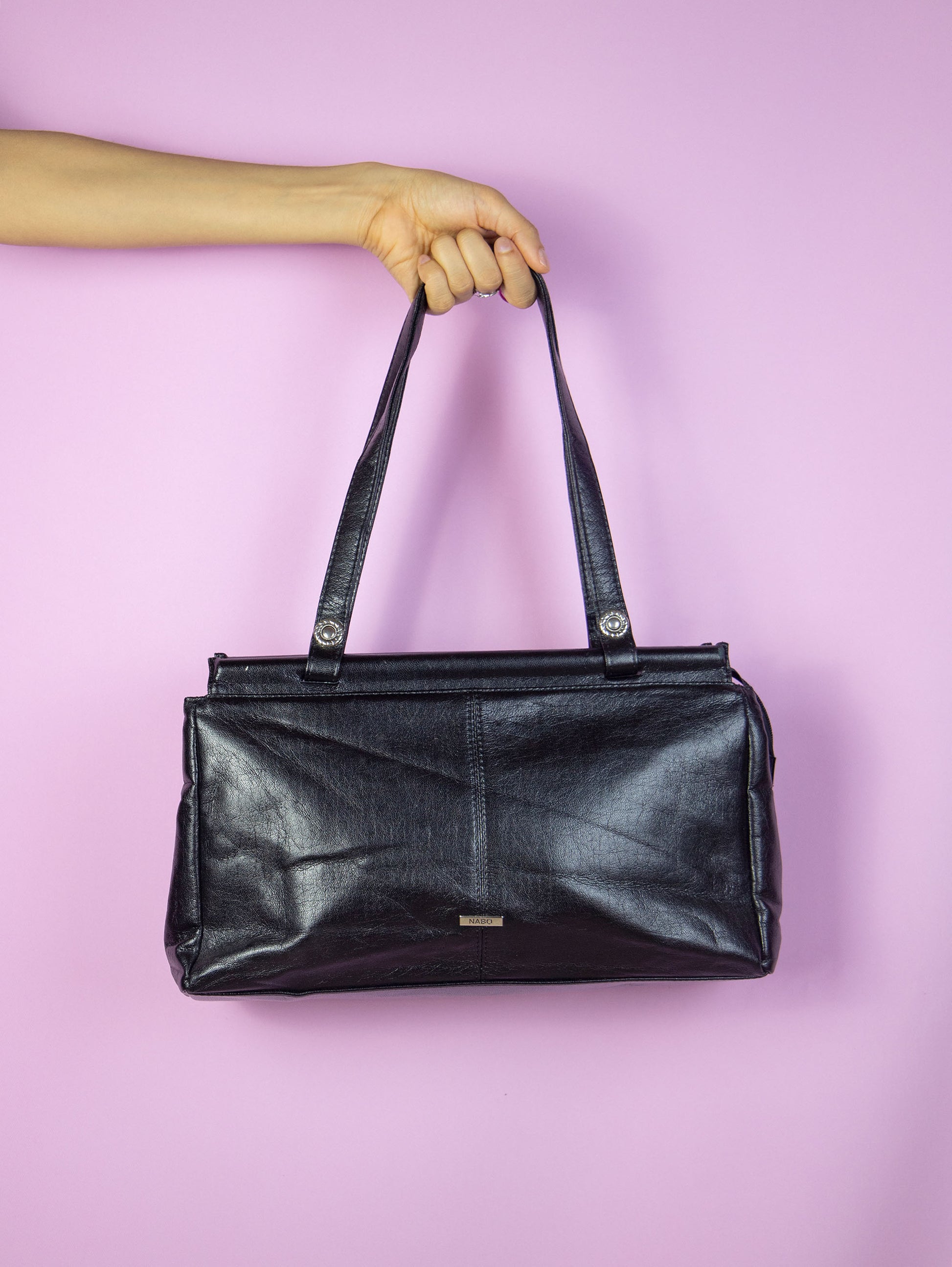 The Vintage 90s Black Shoulder Bag is a rectangular faux leather bag with several compartments, zipper closure and double handle. Casual retro minimalist 1990s handbag.