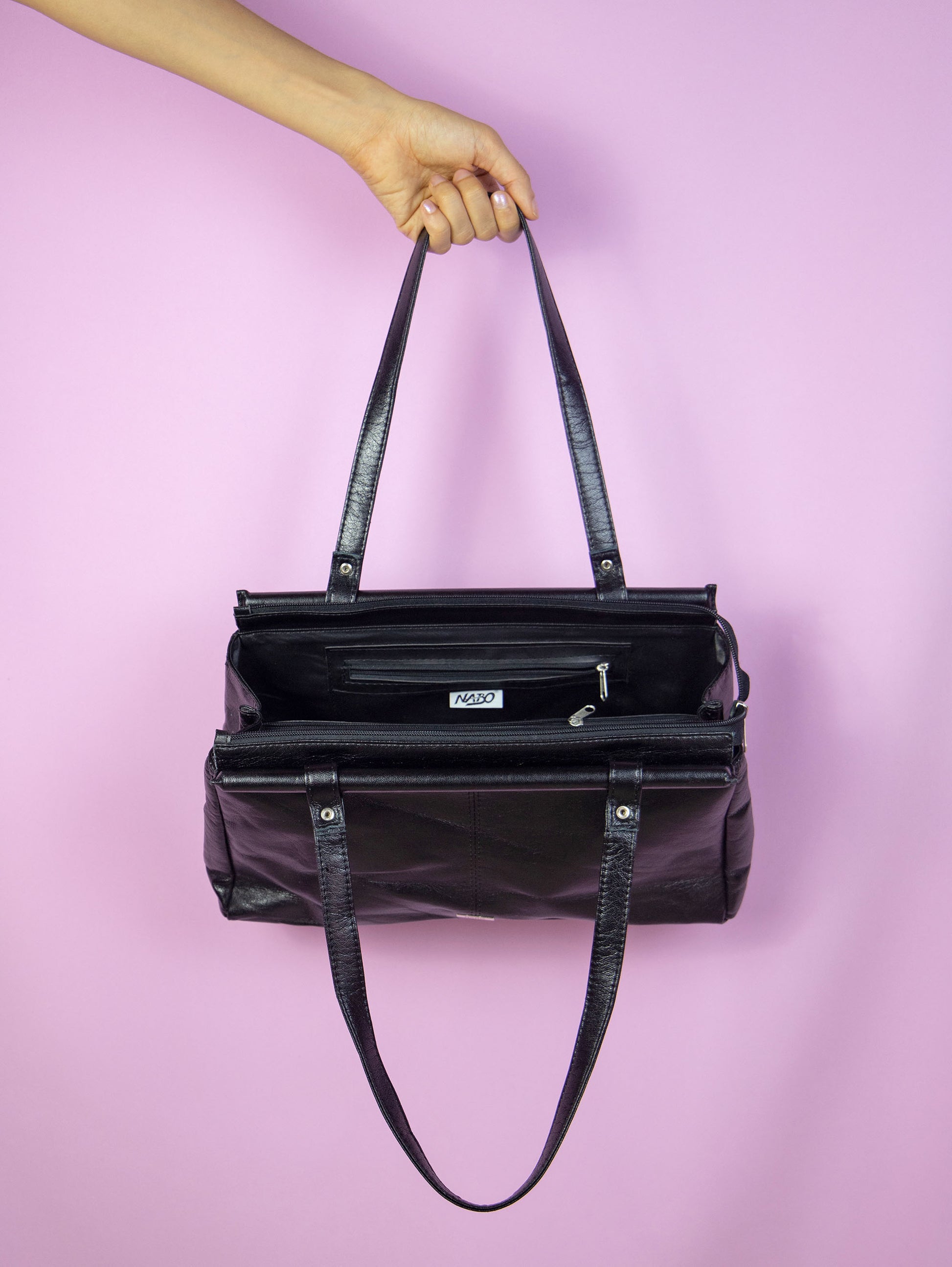The Vintage 90s Black Shoulder Bag is a rectangular faux leather bag with several compartments, zipper closure and double handle. Casual retro minimalist 1990s handbag.