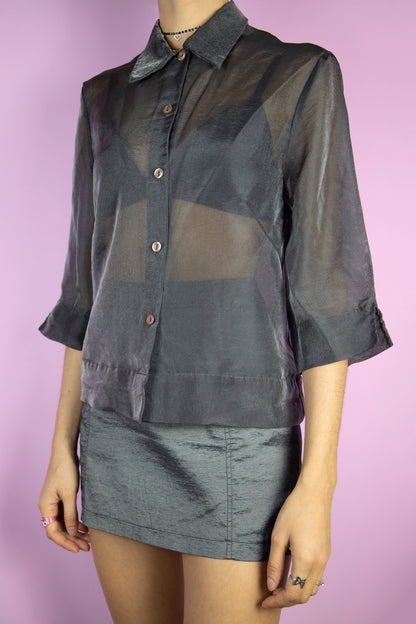 The Vintage 90’s Dark Gray Sheer Top is a shiny semi-sheer gray blouse with a classic collar and button detailing. This gorgeous shirt perfectly embodies the spirit of party night fashion from the 1990s.