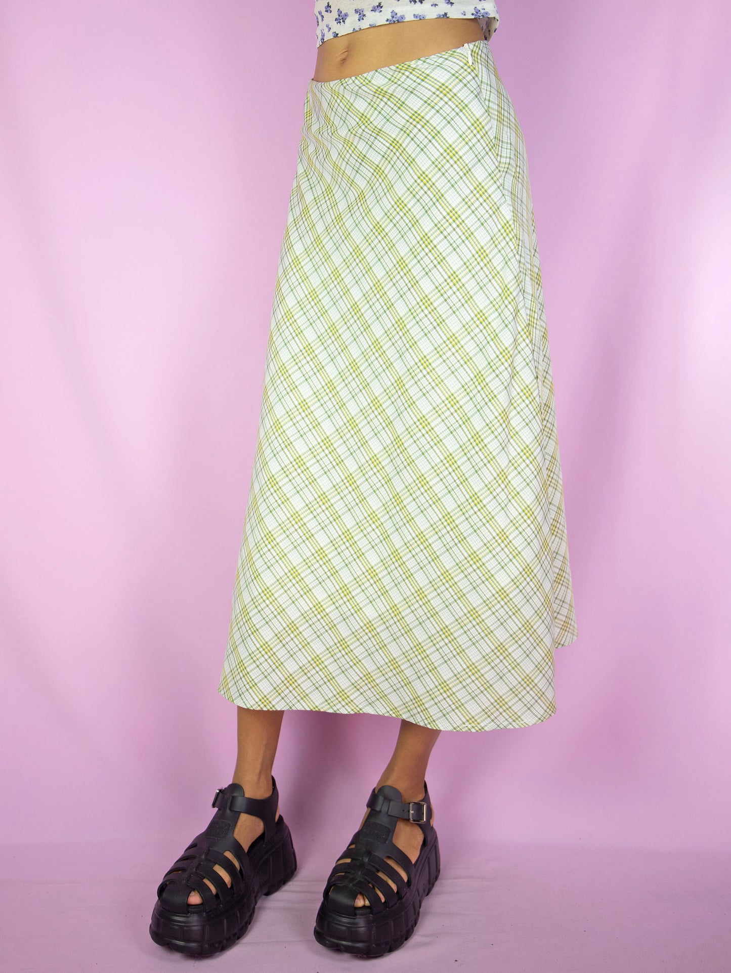 The Y2K Green Plaid Midi Skirt is a vintage flared beige yellow green plaid skirt with side zipper closure. Cottage prairie inspired 2000s boho preppy check maxi skirt.