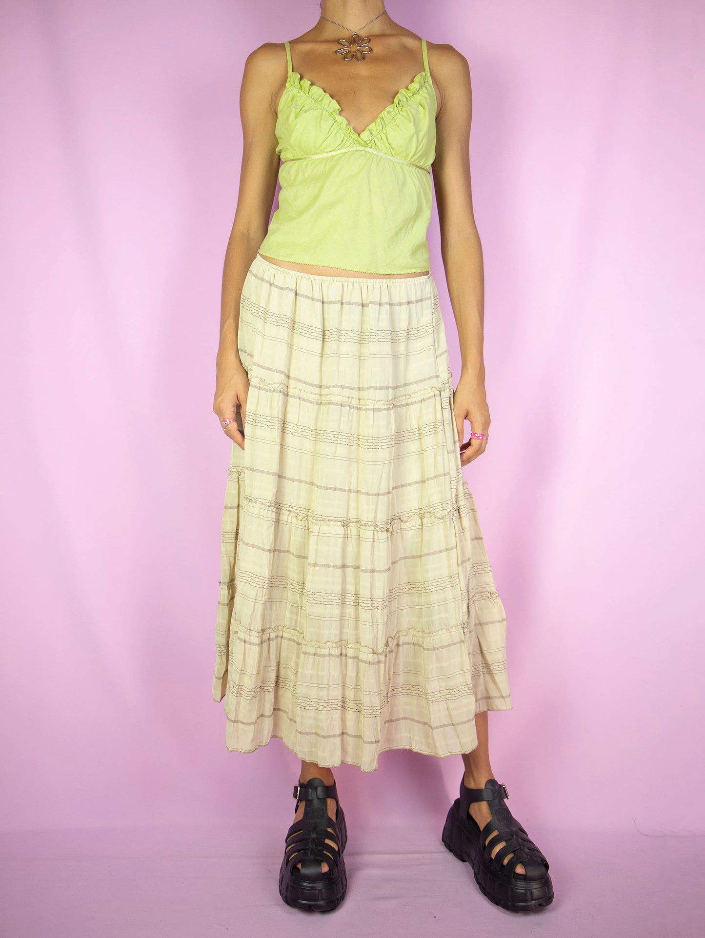 The Vintage 90s Beige Tiered Midi Skirt is a beige and brown striped tiered skirt with an elastic waist. Cottage prairie milkmaid inspired 1990s boho peasant midi skirt.