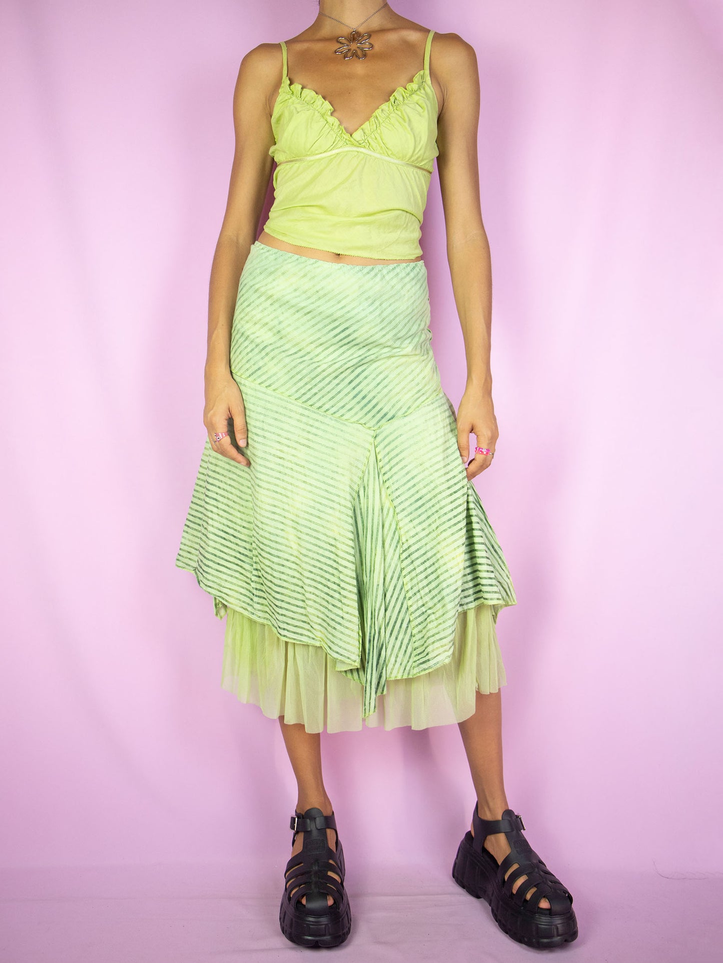The Y2K Green Asymmetric Midi Skirt is a vintage green striped skirt with pointed asymmetric layers, semi-sheer mesh hem and elastic waist. Cyber fairy grunge 2000s boho pixie midi skirt.