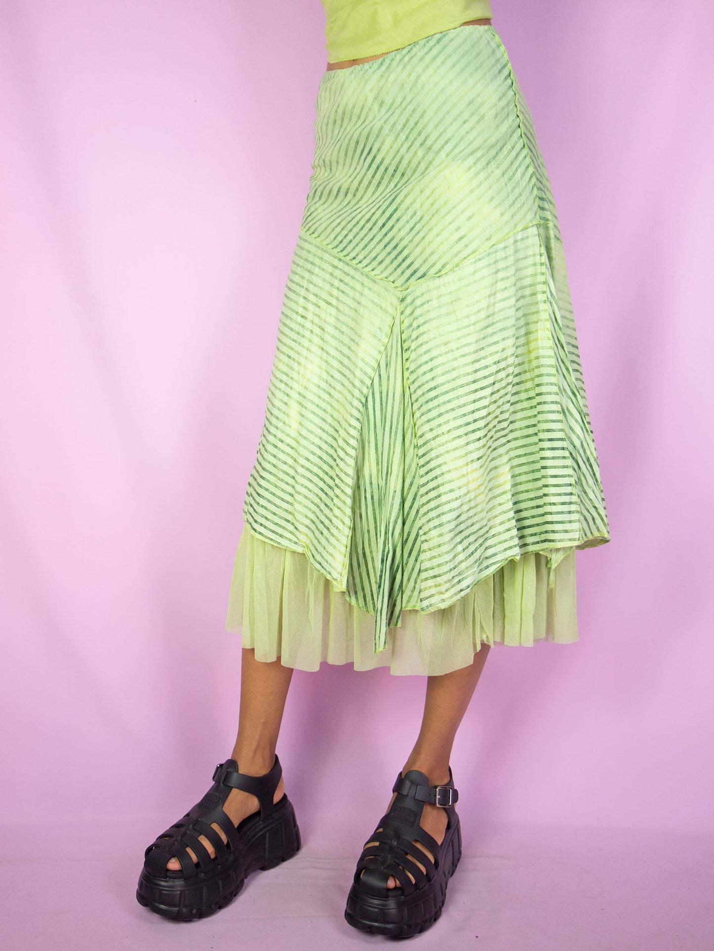 The Y2K Asymmetrical Layered Midi Skirt is a vintage 2000s cyber fairy festival party style green striped print skirt with pointed asymmetric layers, semi-sheer mesh hem and elastic waist.