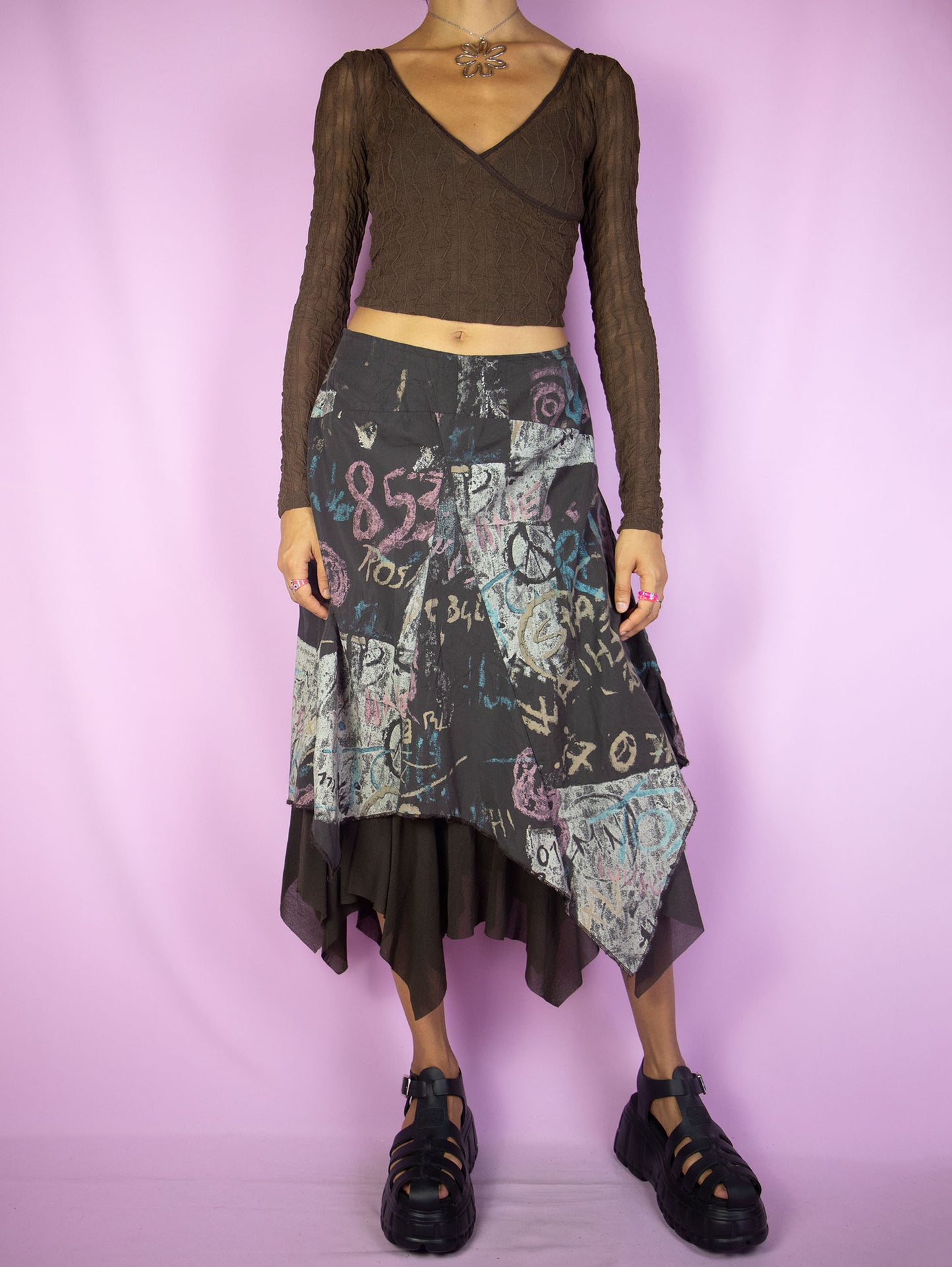 The Y2K Cyber Asymmetric Midi Skirt is a vintage dark brown abstract pointed asymmetrical layered skirt with semi-sheer mesh hem and side zipper closure. Whimsygoth fairy grunge 2000s subversive party midi skirt.